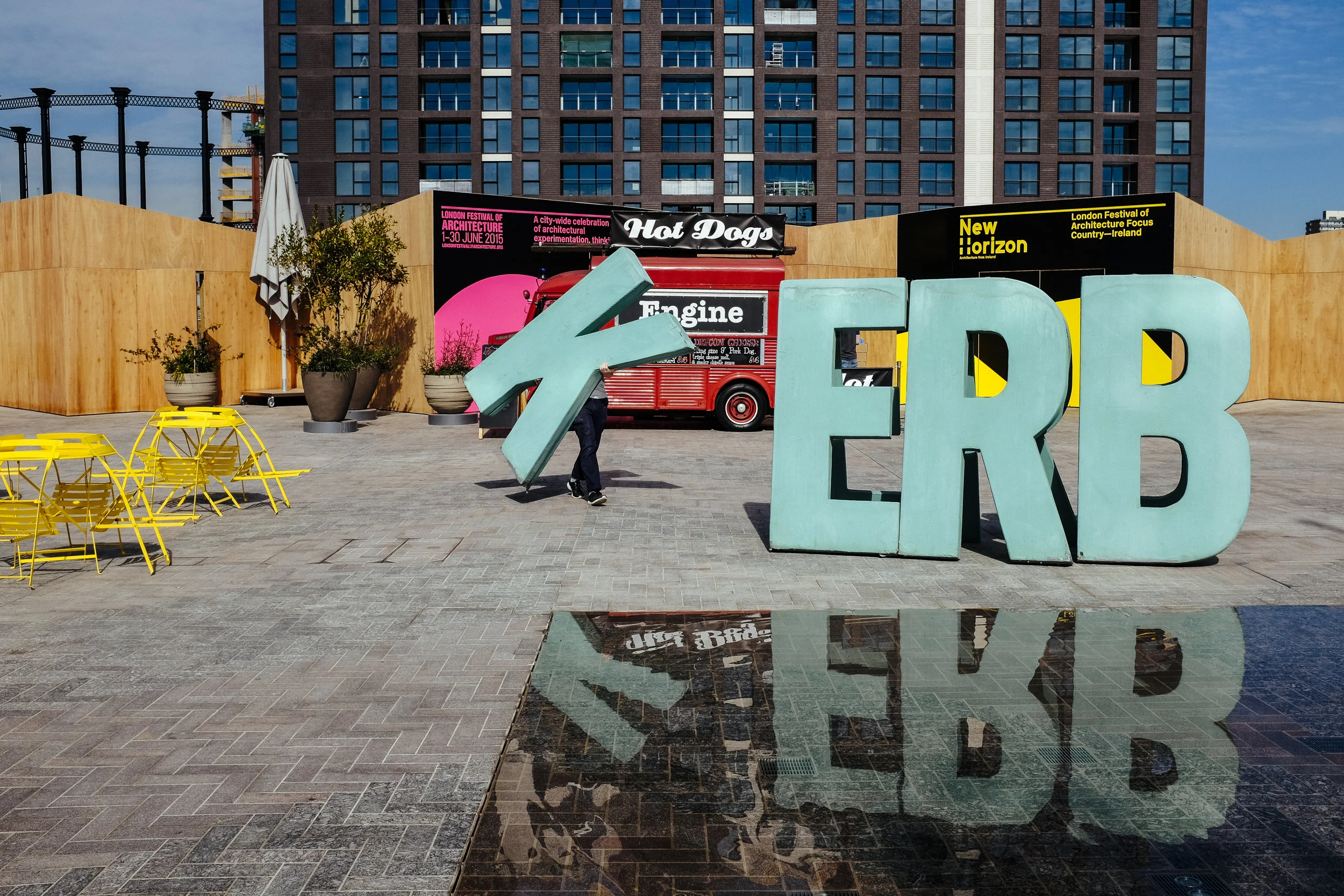 Ian, who works for Kerb, an organization that helps turn public spaces over to traders selling food, carries a letter to spell out Kerb as he prepares for traders to arrive in Cubitt Square, King's Cross, London, Thursday, June 4, 2015.