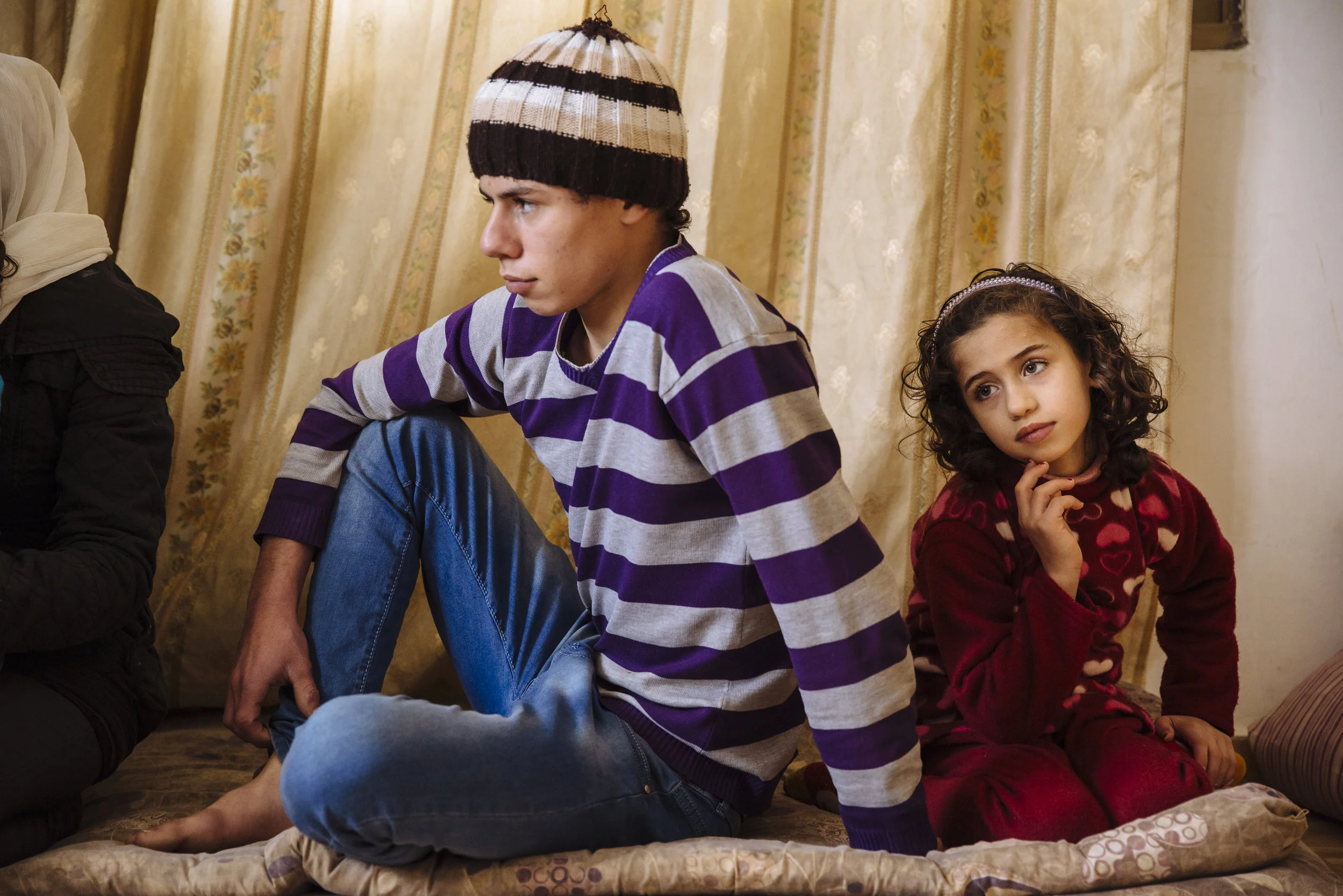 Syrian refugee Oday, 15, and his sister Diyala, 7, sit in the family's rented apartment in Madaba, Madaba Governorate, Jordan.