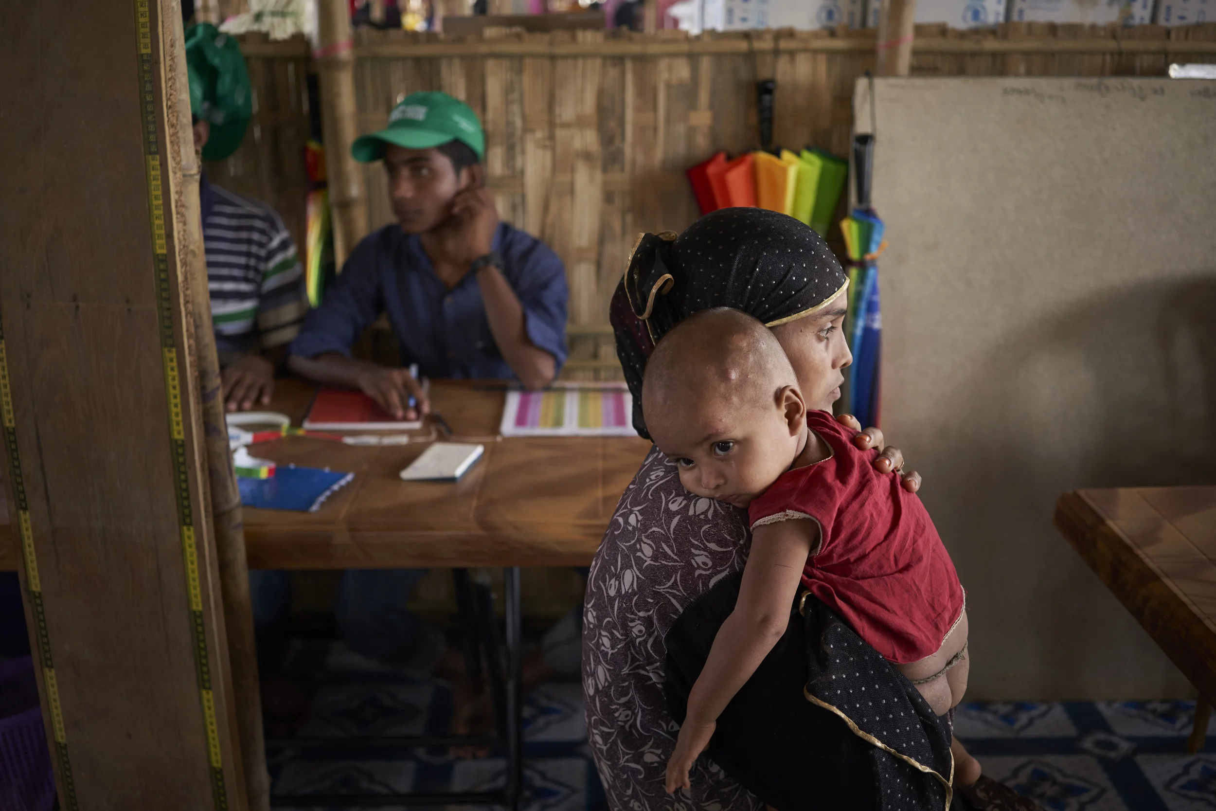 Rohingya refugee Mohammad Rahin, 15-months, is held by his mother Moshana, 25, after being weighed at a UNHCR Outpatient Therapeutic Program (OTP) site in Kutupalong Expansion Site for Rohingya refugees, Ukhia, Cox's Bazar District, Bangladesh.