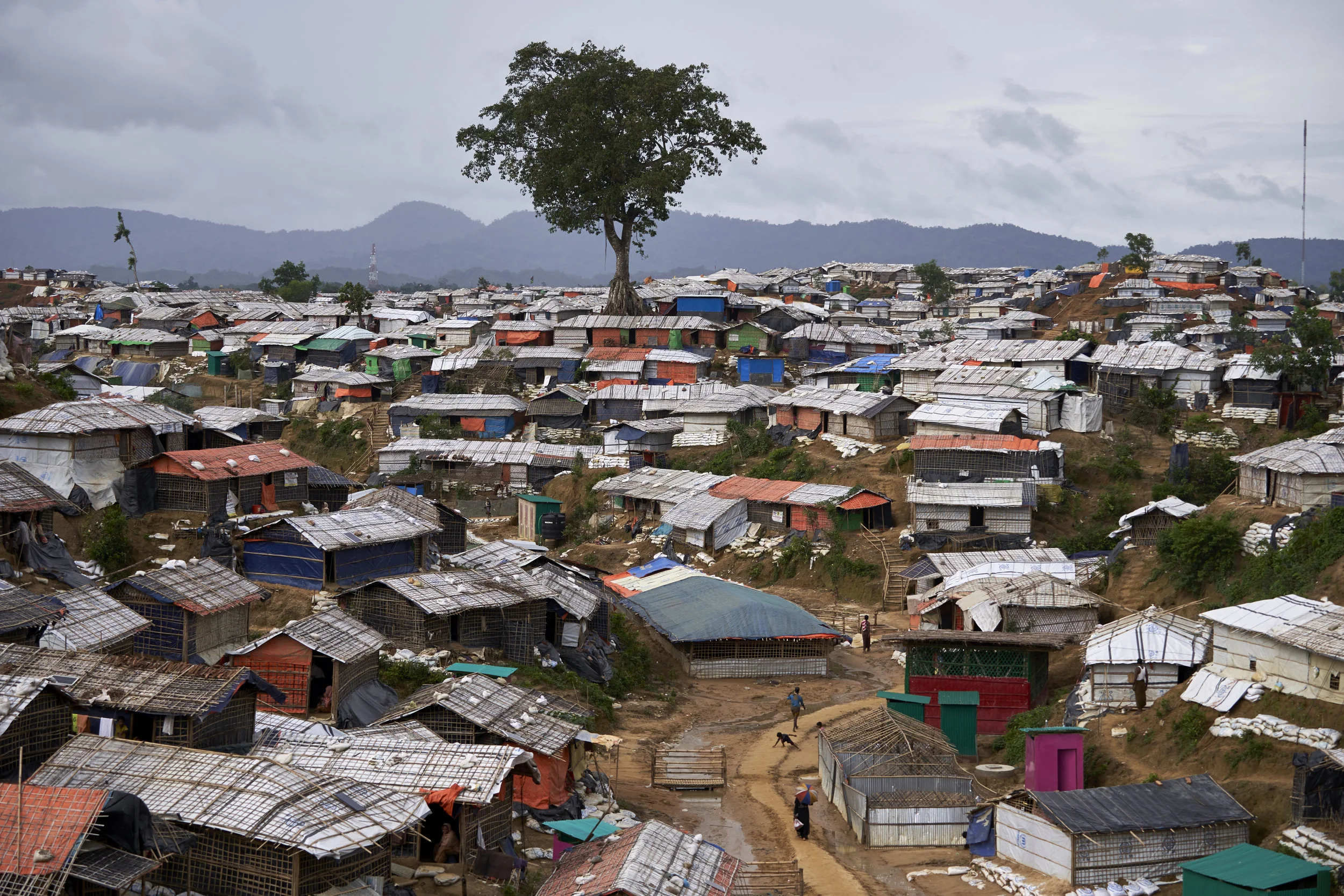 Rohingya refugee make their way along a path surrounded by shelters in Balukhali settlement for Rohingya refugees, Ukhia, Cox's Bazar District, Bangladesh.