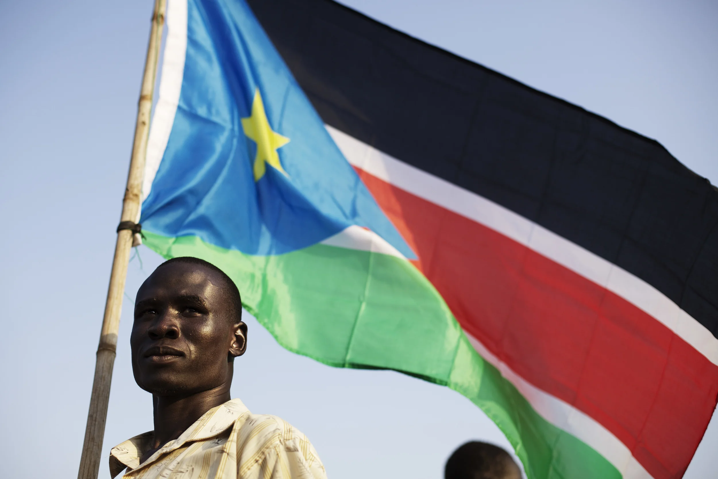 A Bari community member holds the flag of South Sudan during celebrations on the eve of South Sudan's declaration of independence in Juba, southern Sudan, Friday, July 8, 2011. (AP Photo/David Azia)