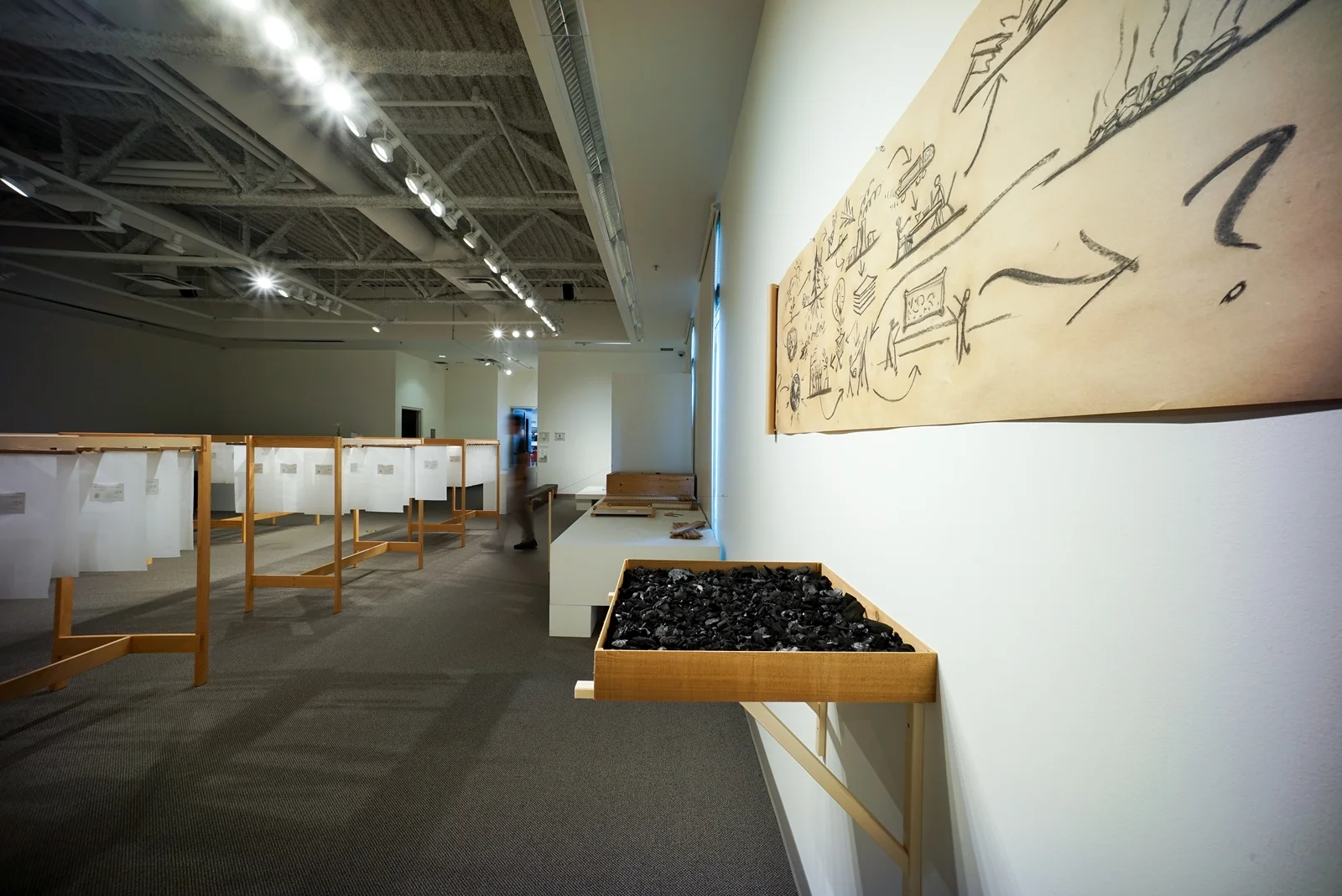 The Charcoal installation by Mizzonk, where fragments of past fires form a drawing that speaks to life's constant state of becoming and transformation.