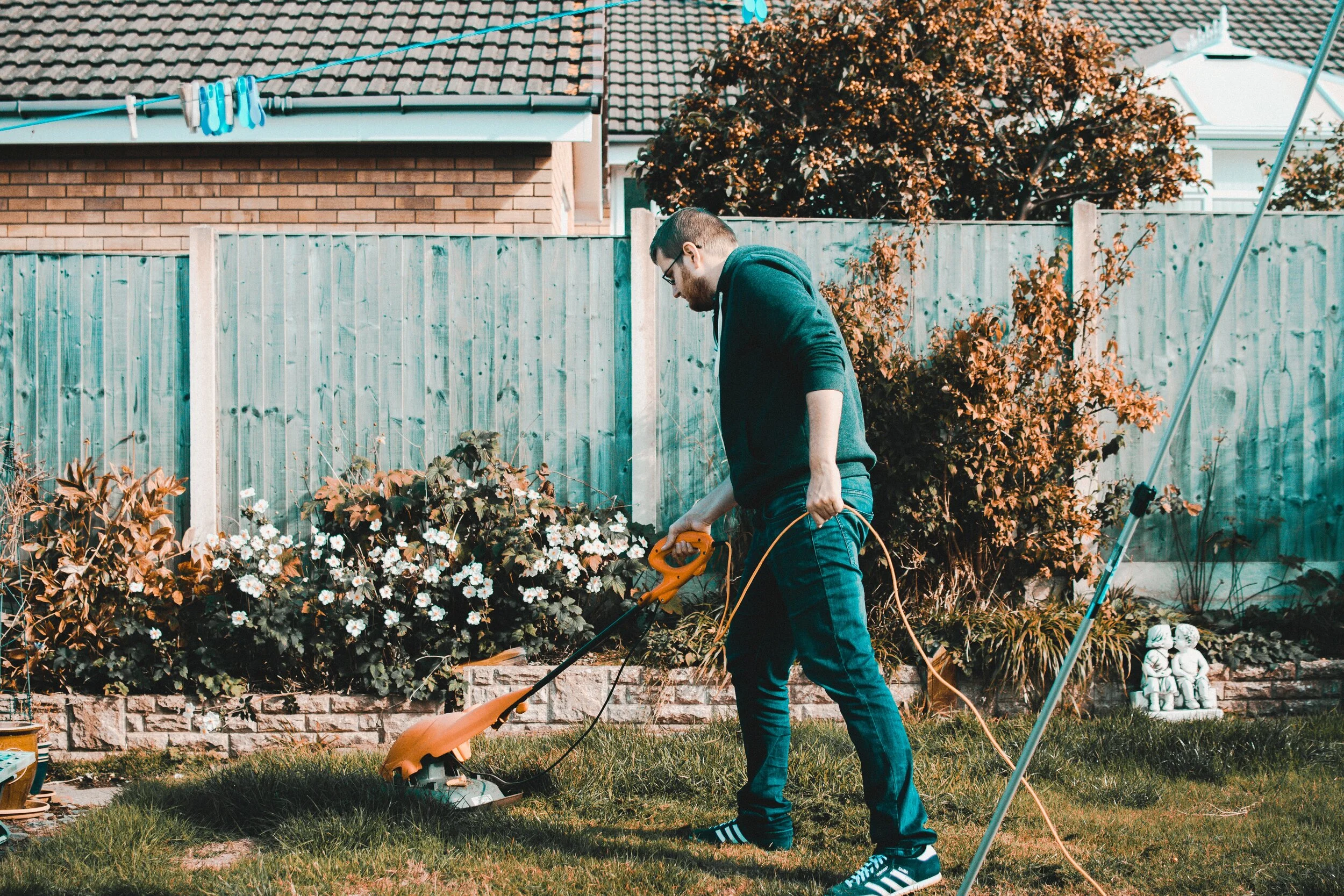 https://www.pexels.com/photo/man-holding-orange-electric-grass-cutter-on-lawn-1453499/