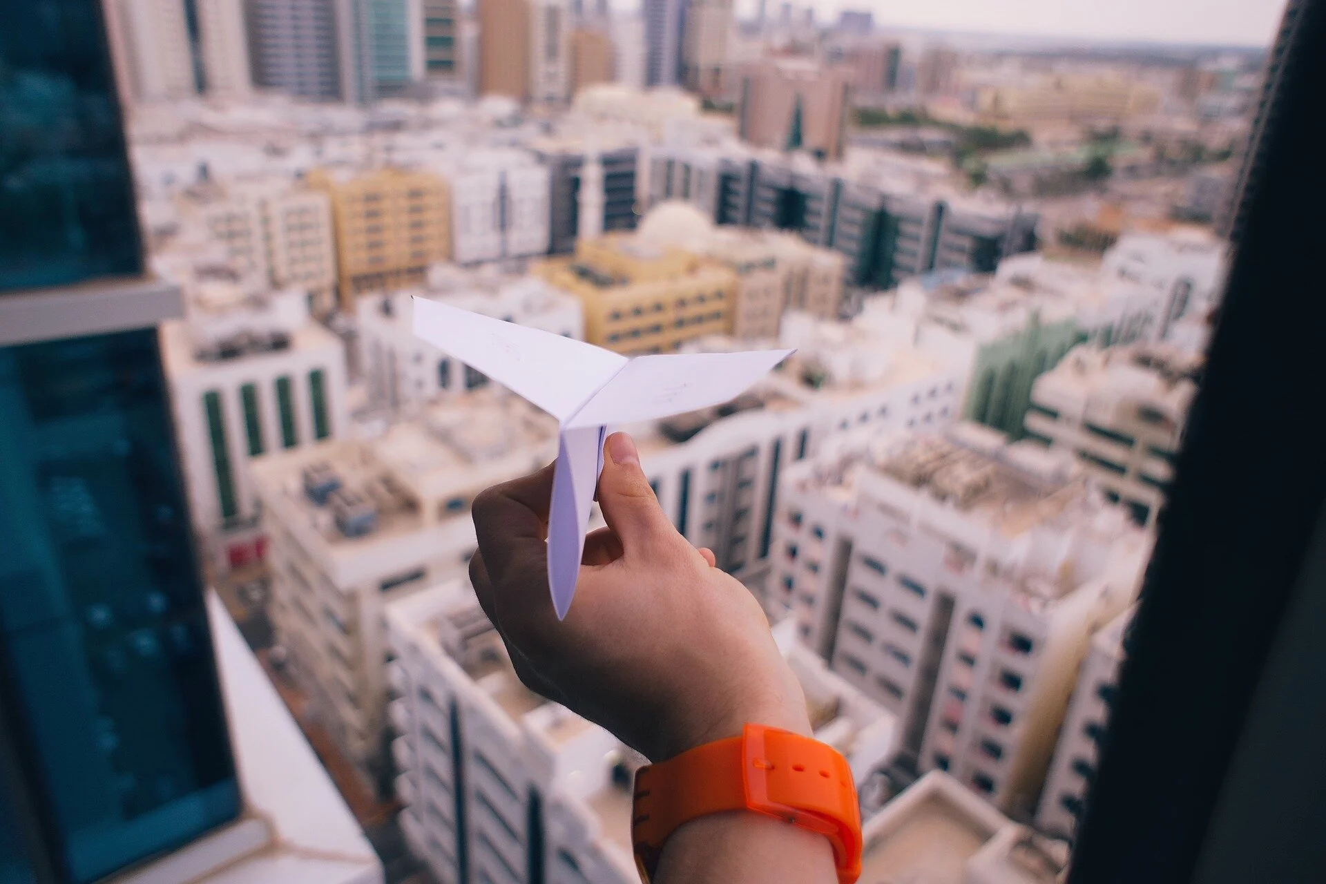 Hand flying paper airplane.jpg