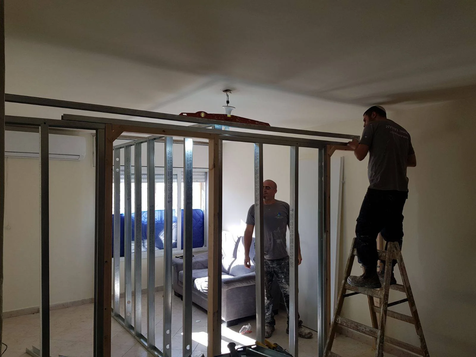 Tenufa Bakehila workers rebuilding a home in Israel.
