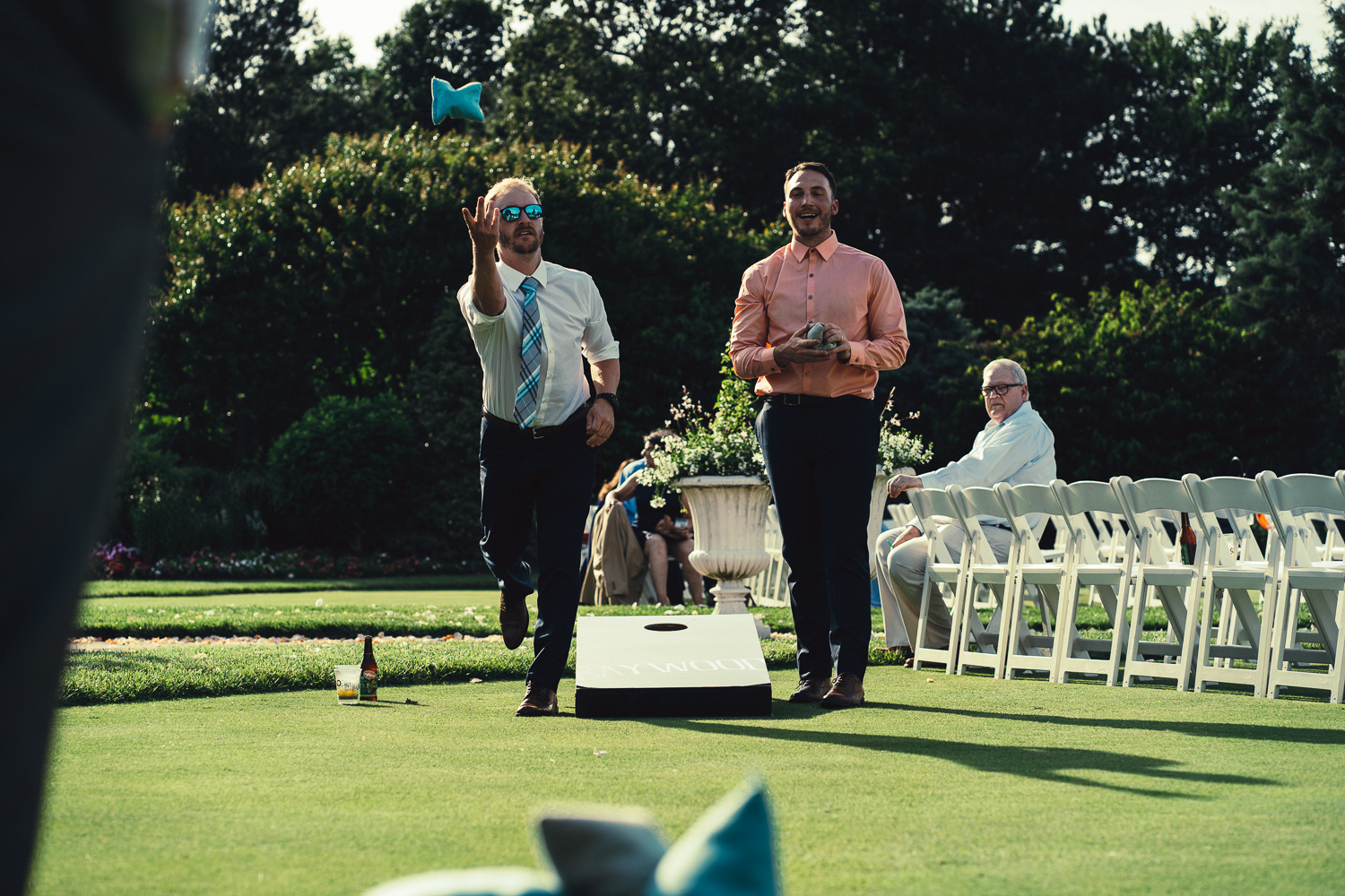 Guests challenge each other at corn hole during cocktail hour