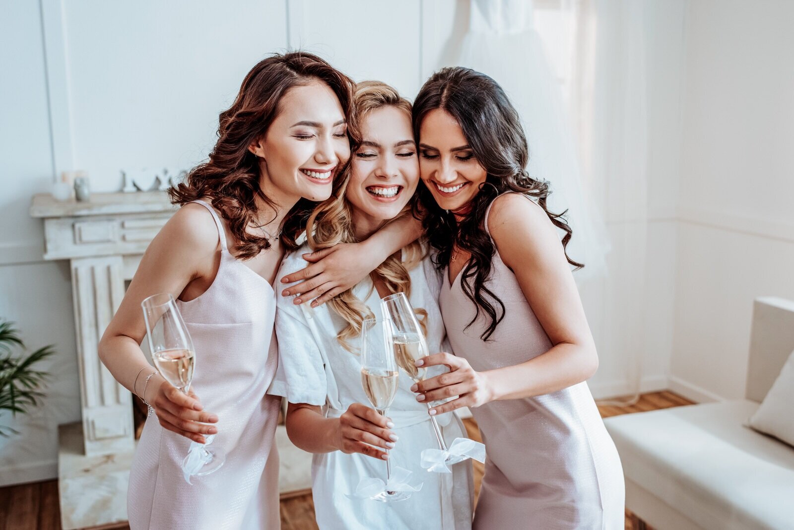 Bridal party hugging in hotel room while preparing for Hawaii wedding