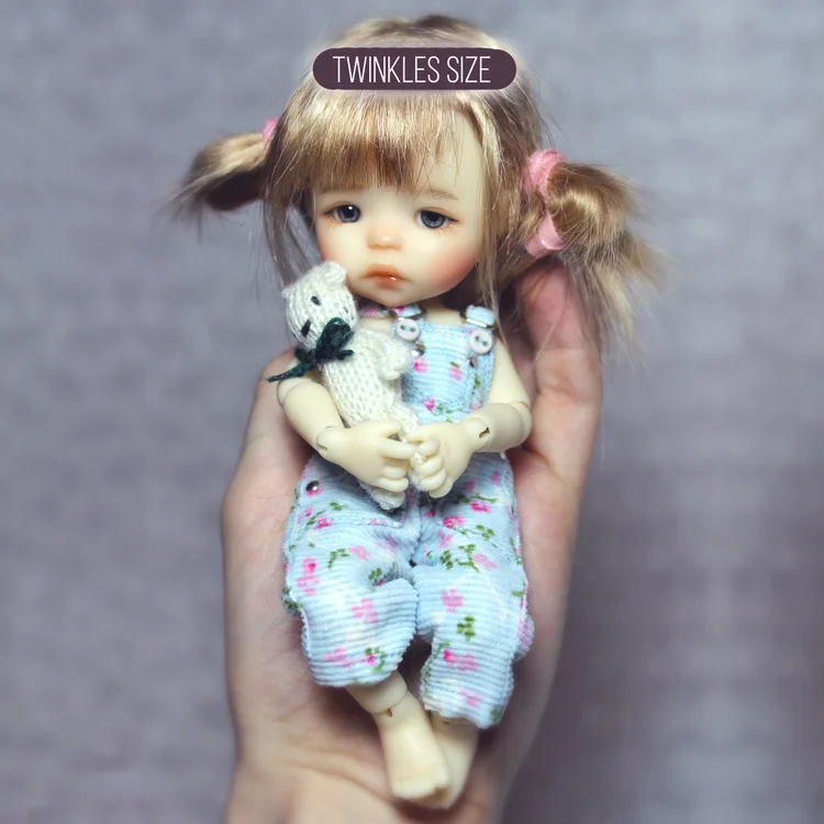 A tiny Twinkle doll in a hand
