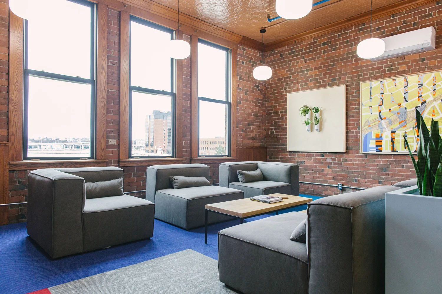 Lounge seating in the Saint John Concourse below brick walls and tall windows