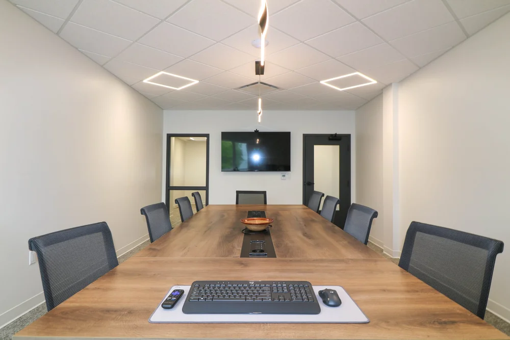 The Beaverbrook boardroom: long wood table for 12 facing a large TV