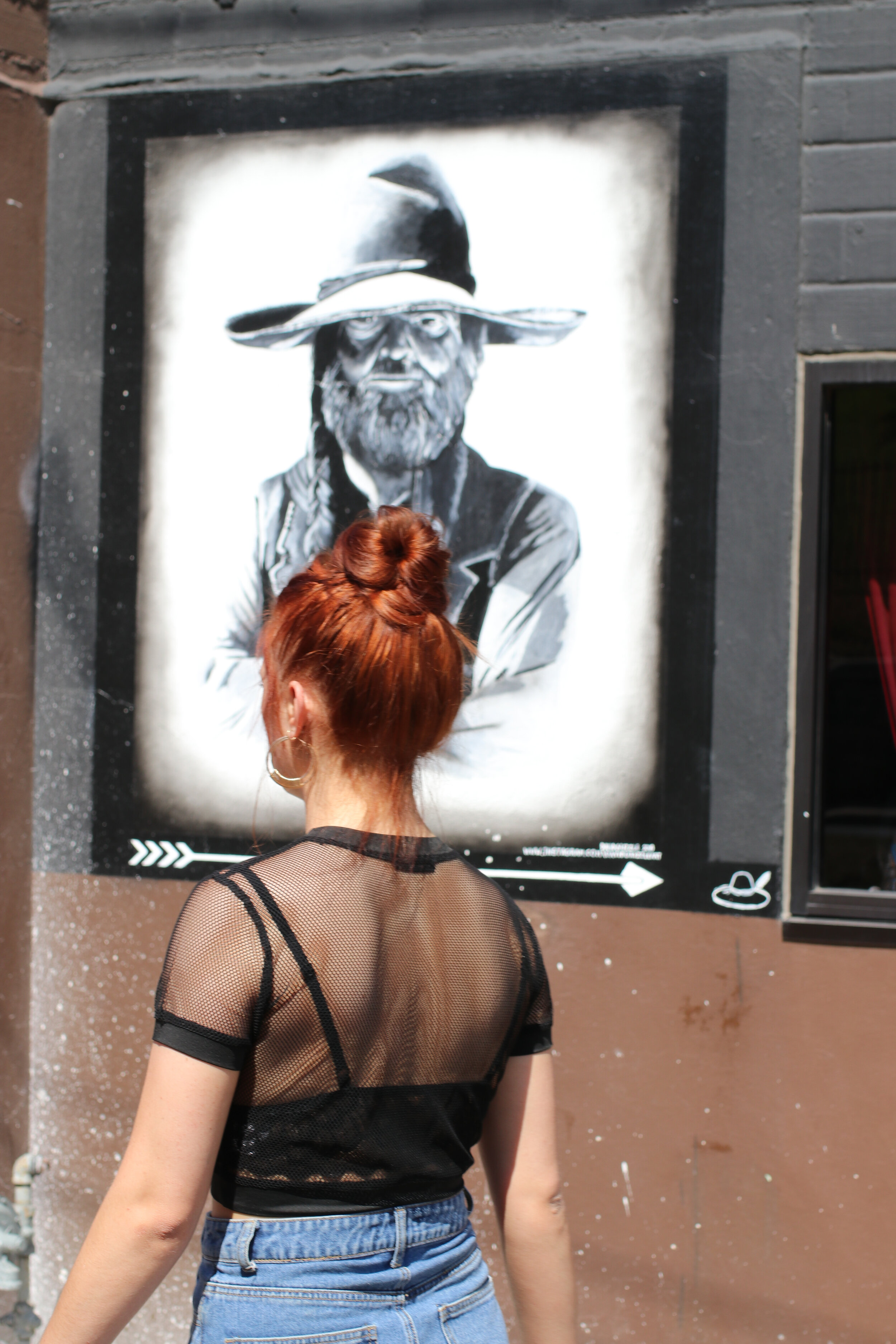  Woman walks past Aspen Hatters on her way to ACL Festival on Barton Springs Road 