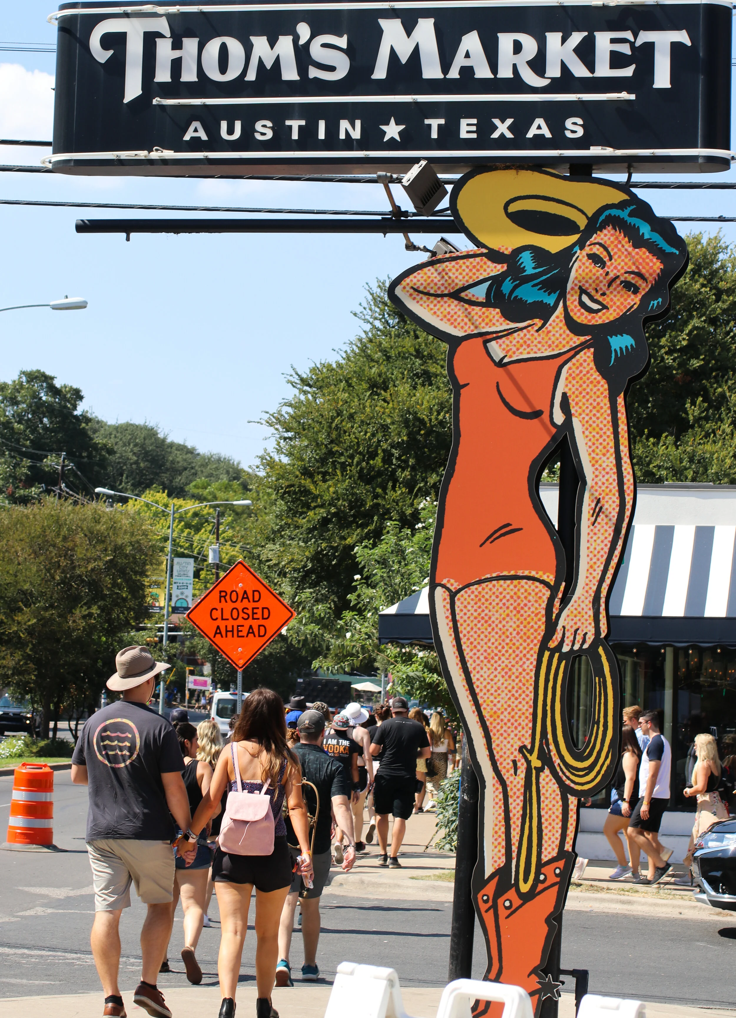 Festival guests walk past Thom’s Market on Barton Springs Road, heading to ACL Fest.