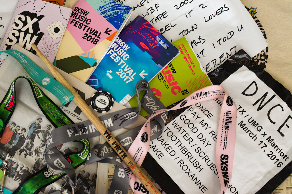  A collection of various music festival guides, setlists, and lanyards. 