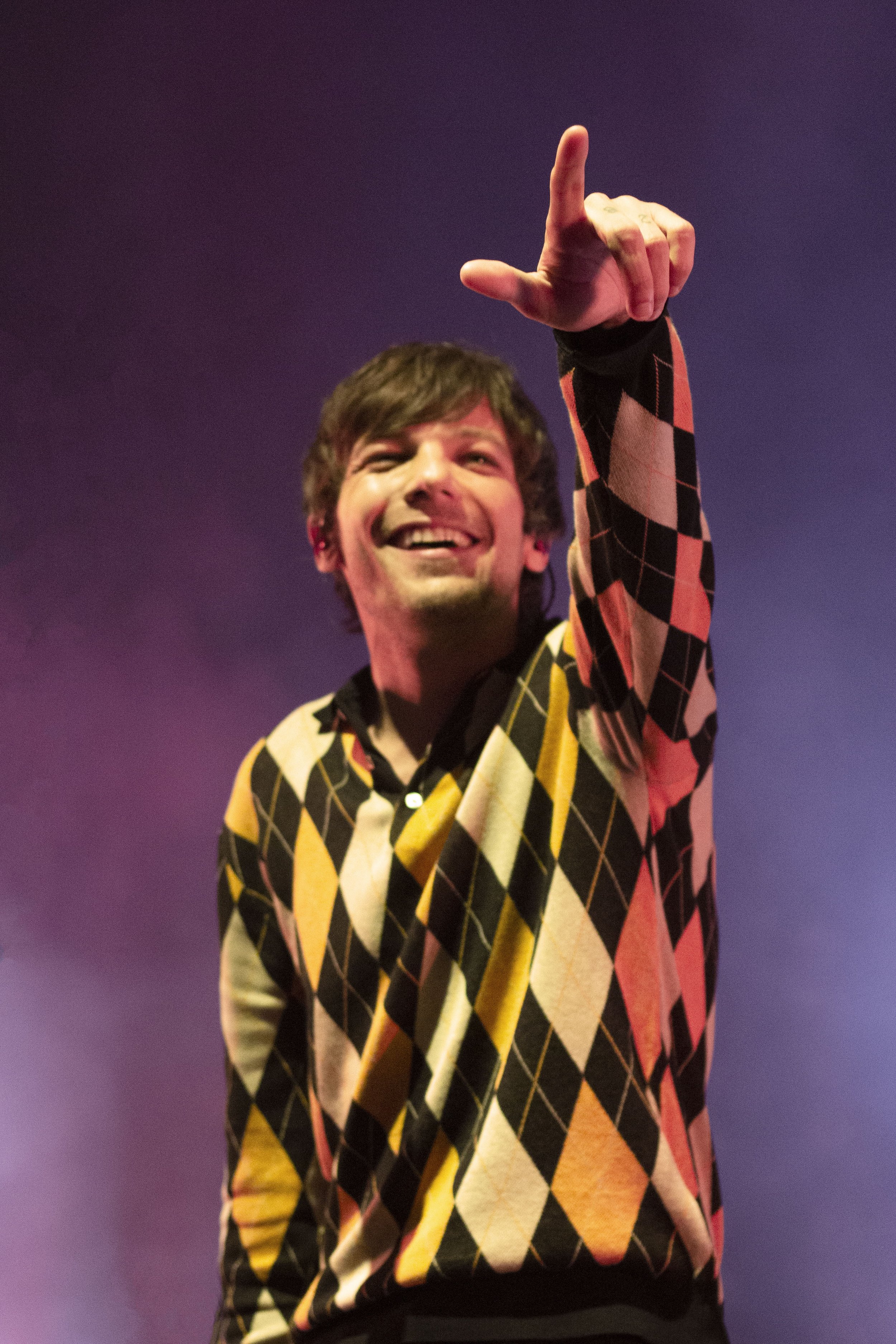  Louis Tomlinson points out a fan in the crowd. 