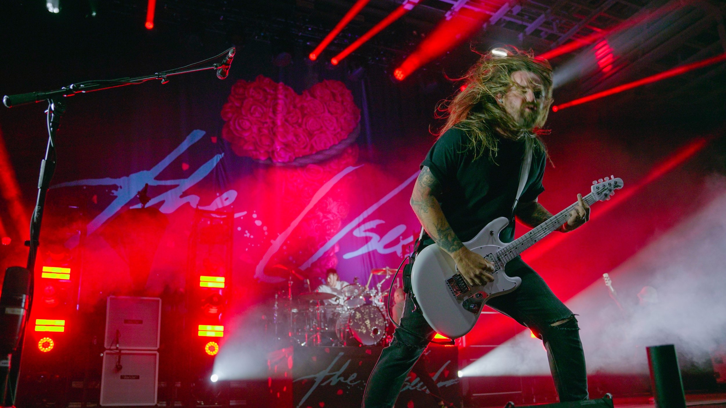  Guitarist Joey Bradford thrashes his guitar during “Take It Away,” headbanging on the downbeat while still picking away at his Sterling StingRay guitar. 