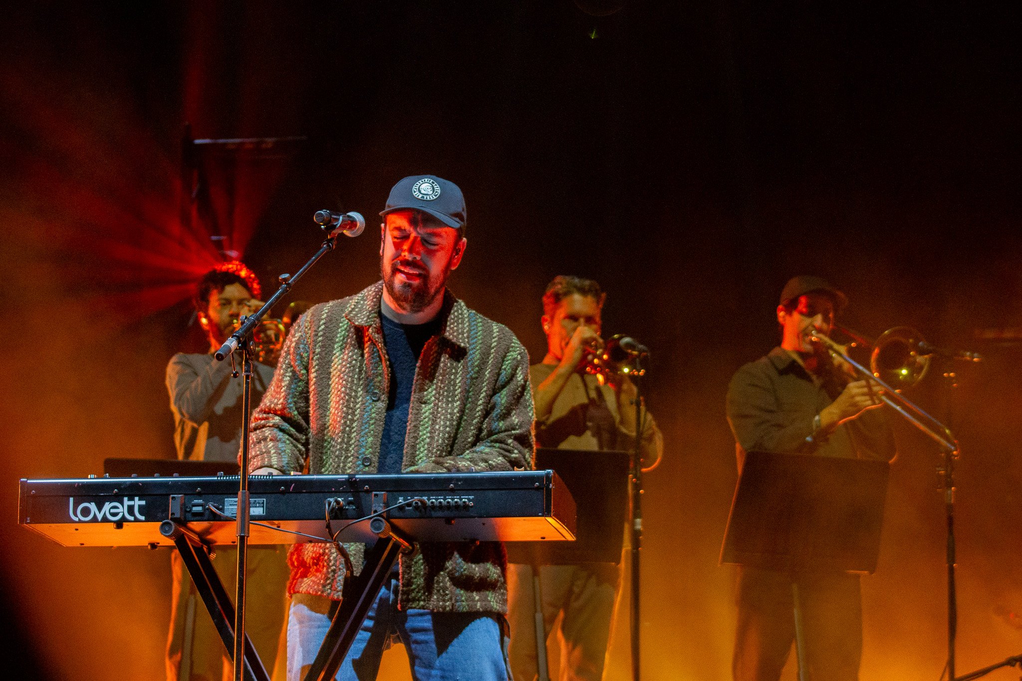  Ben Lovett, backed by trombone players, plays keyboard for Mumford &amp; Sons’ song “Guiding Light.” 