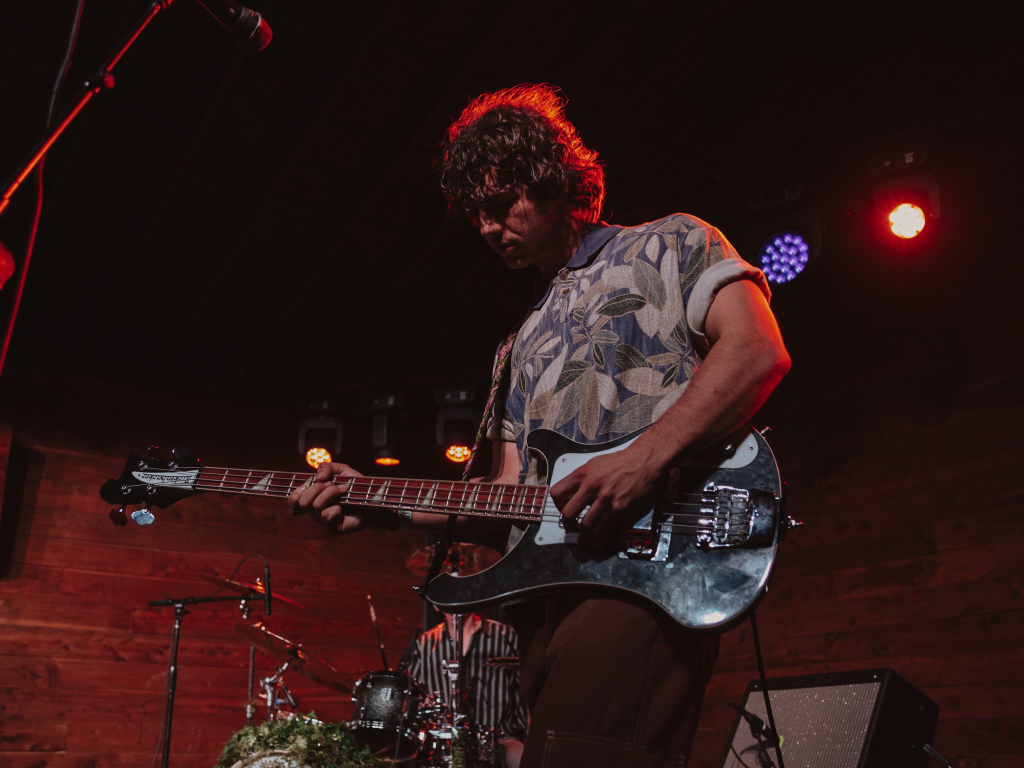  Bassist Caiden Jackson performs with concentration under the stage’s red lights. 