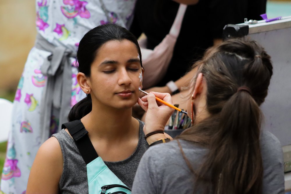  A student gets her face painted at one of the many activity stations at Longhornchella. 