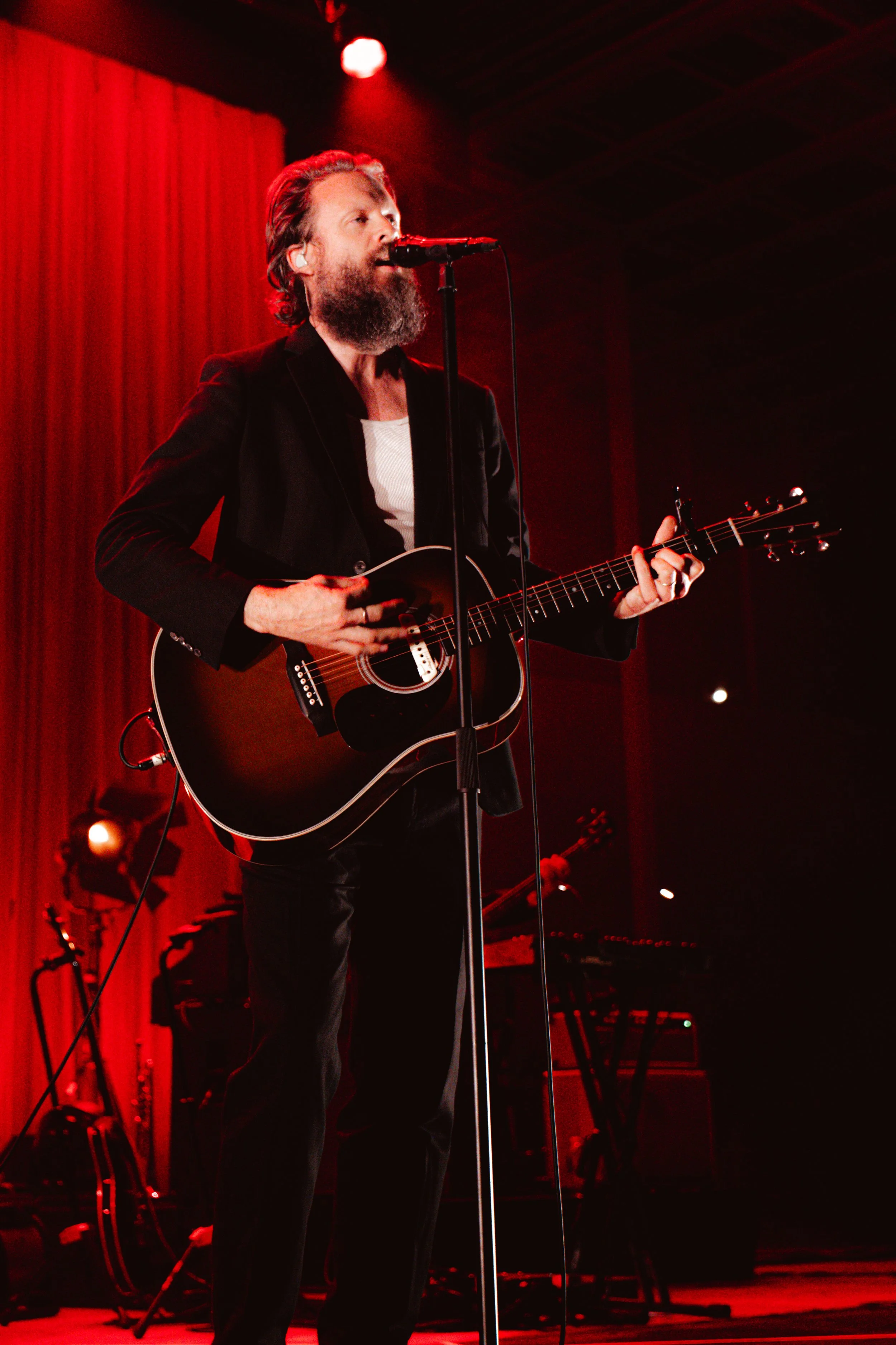 Father John Misty takes the stage with an acoustic guitar and band, playing “I Guess Time Just Makes Fools Of Us All.”