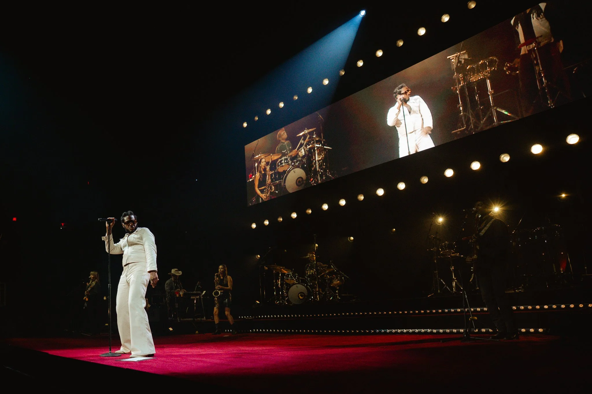With a steady beat on the drums, Bridges performs “Flowers,” his white outfit popping against the rich red velvet stage.