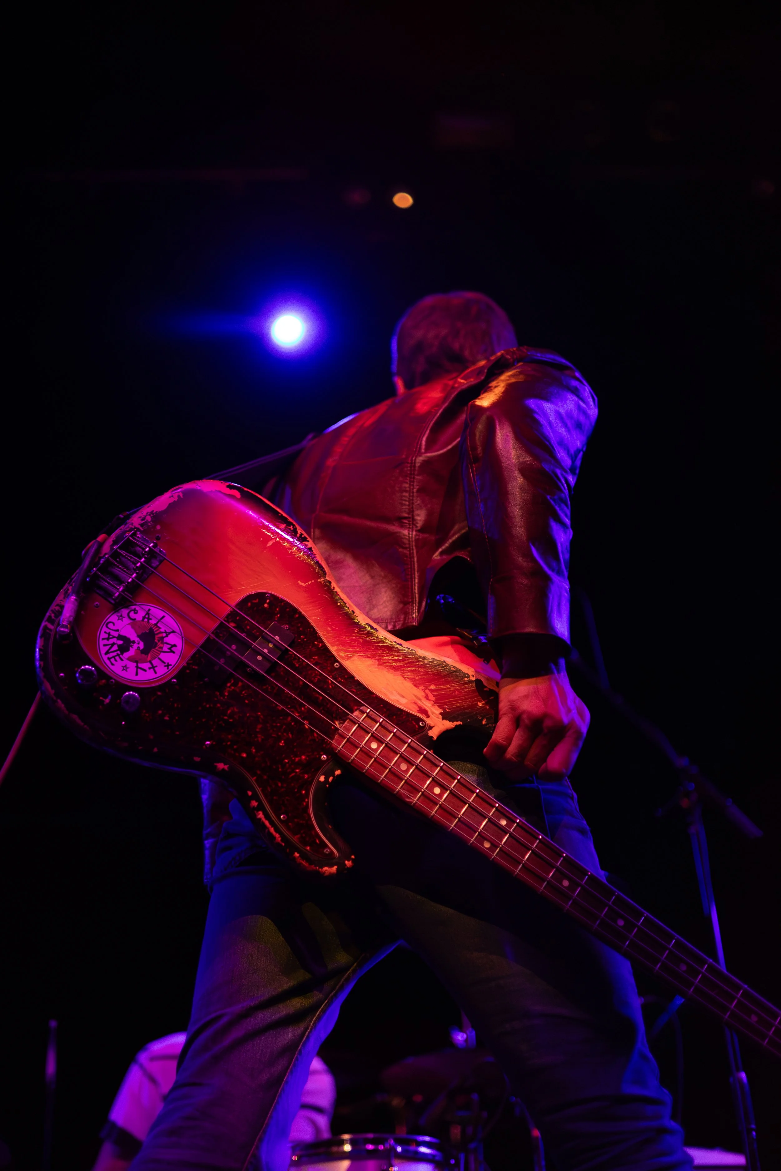 Bass guitarist Gary Jarman swings his instrument as he rocks out on stage during the song “I’m a Realist.”