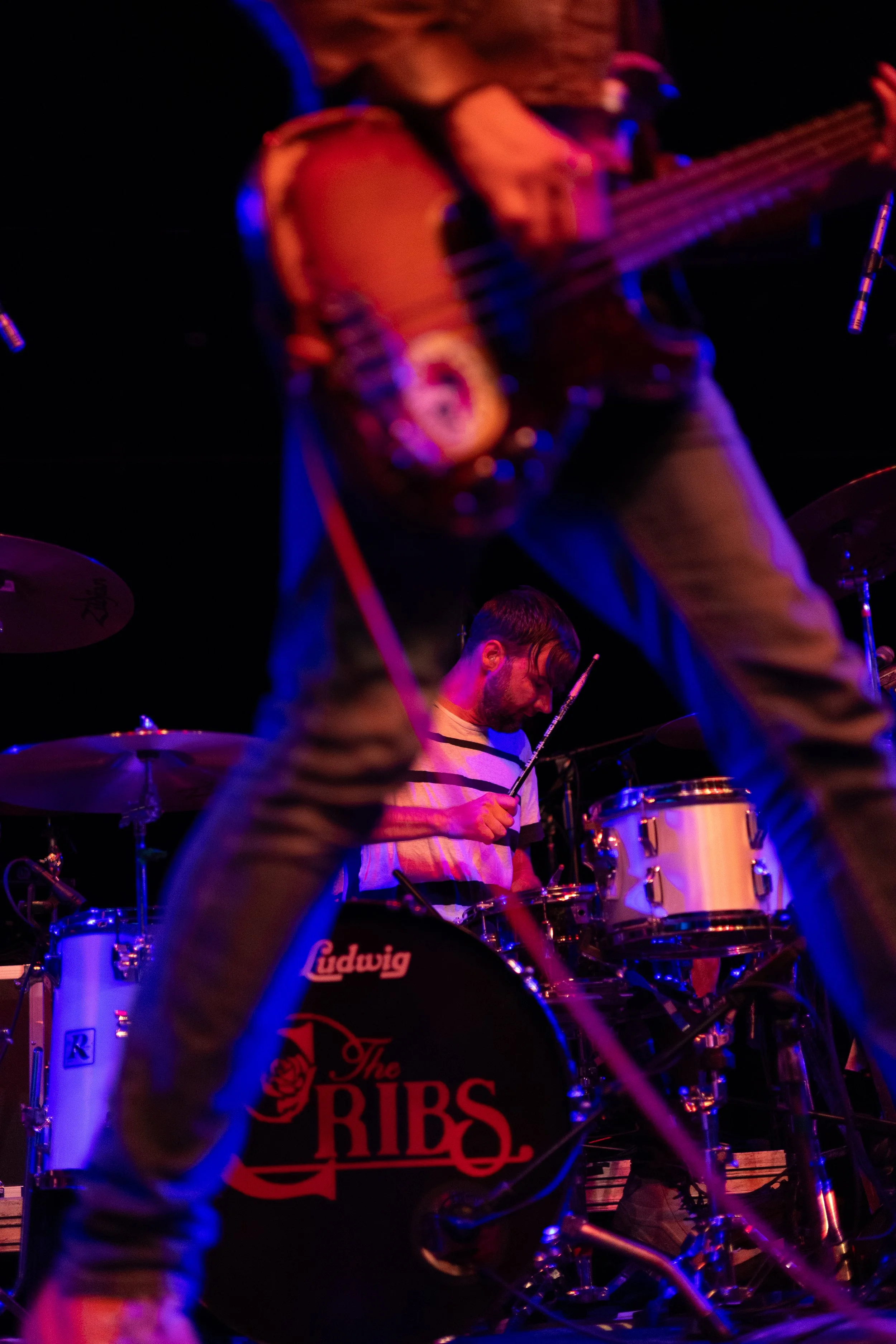 Bass guitarist Gary Jarman swings his instrument as he rocks out on stage during the song “I’m a Realist.”