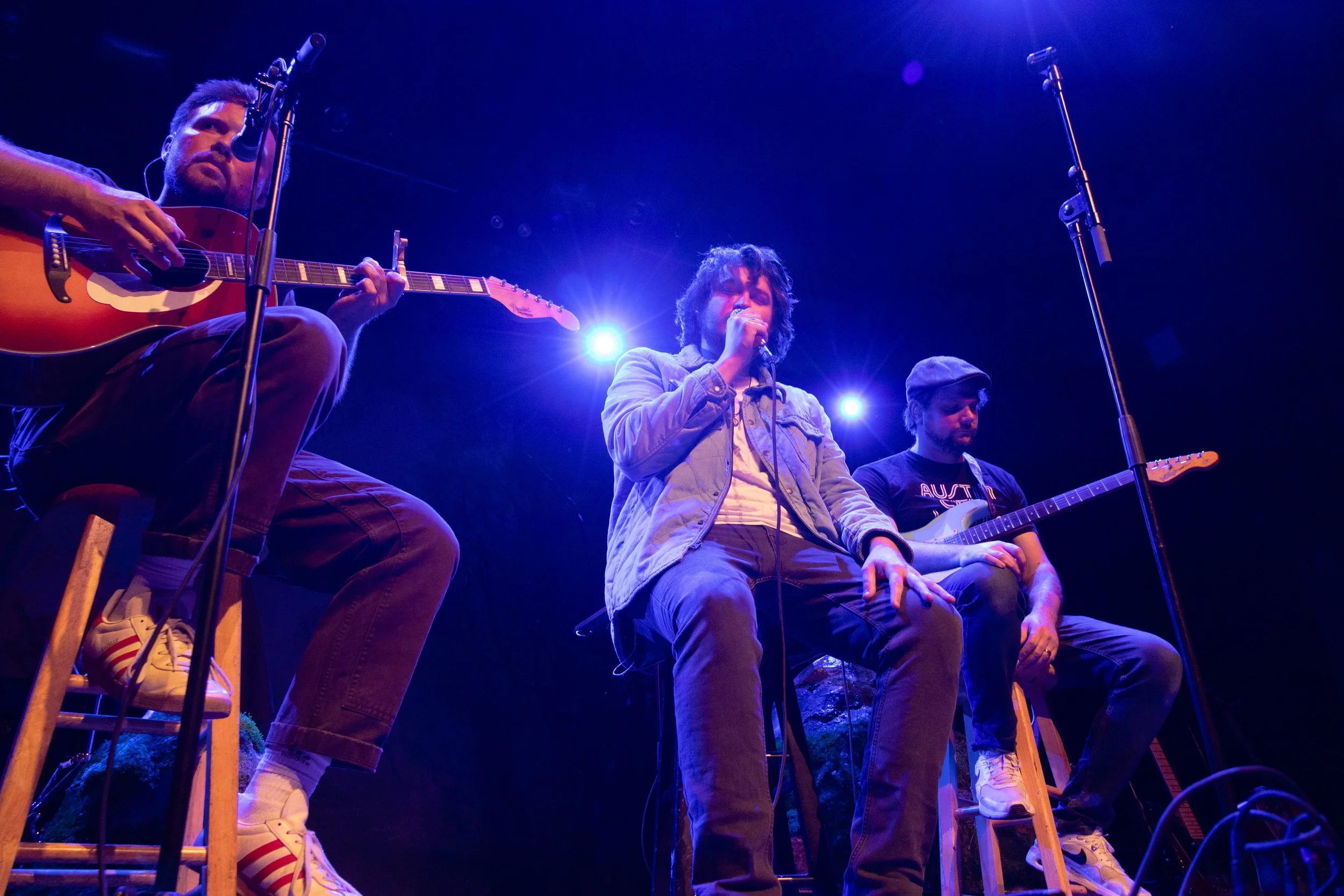  Cyrus sits down with his band while performing the acoustic song “Know This” in blue mood lighting. 