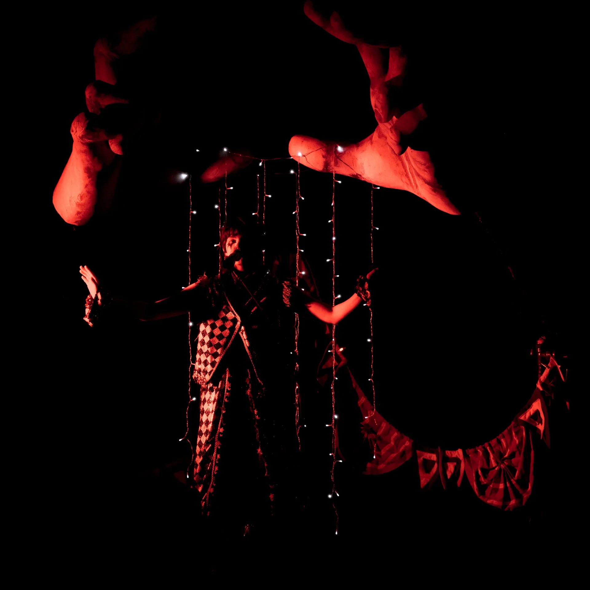  &nbsp;Mei, donning clown makeup and attire, puts on a whimsical performance complete with puppetry gestures that complement their theatrical set. 