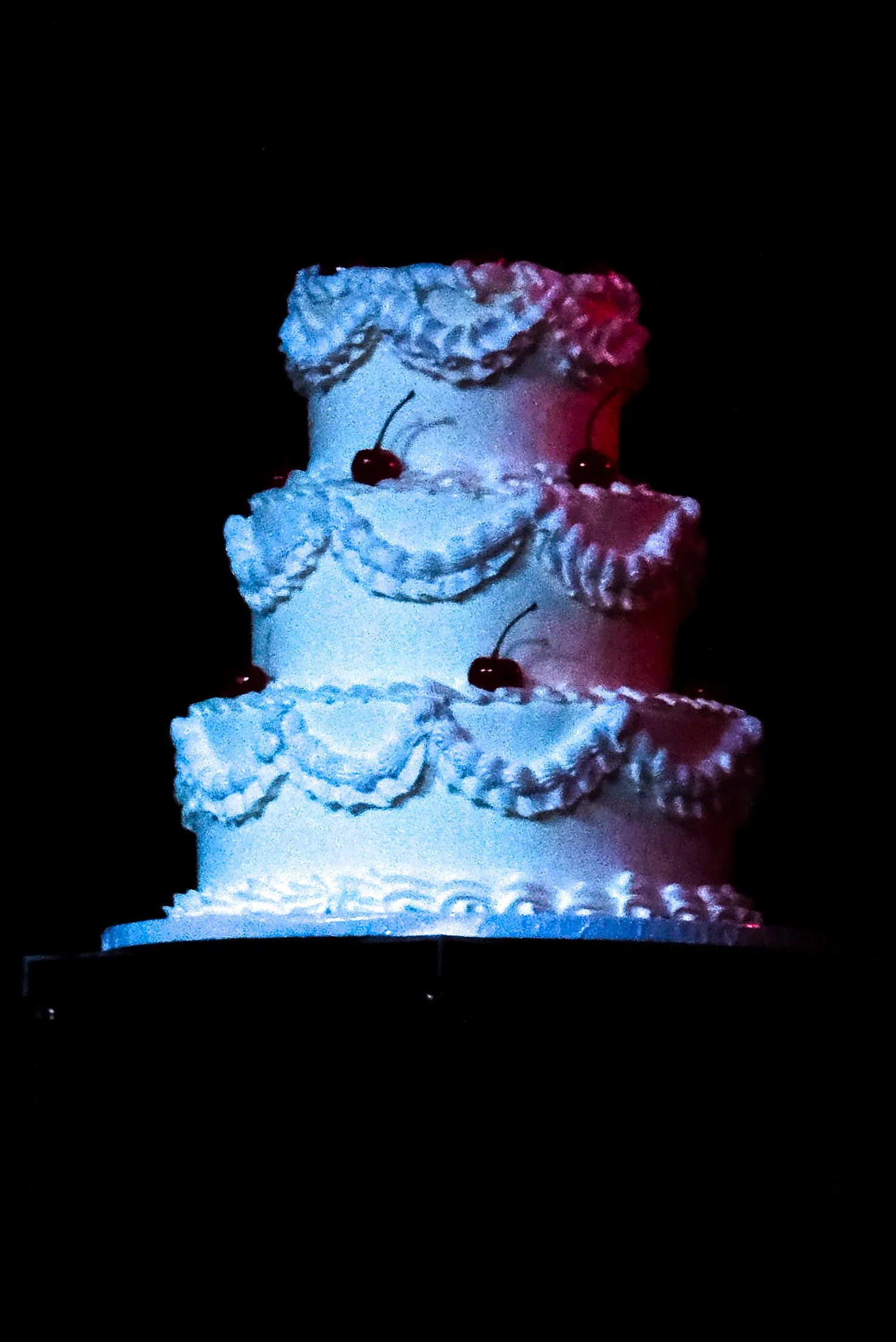  Gates dances in front of a single white three-tier cake, her only prop. 