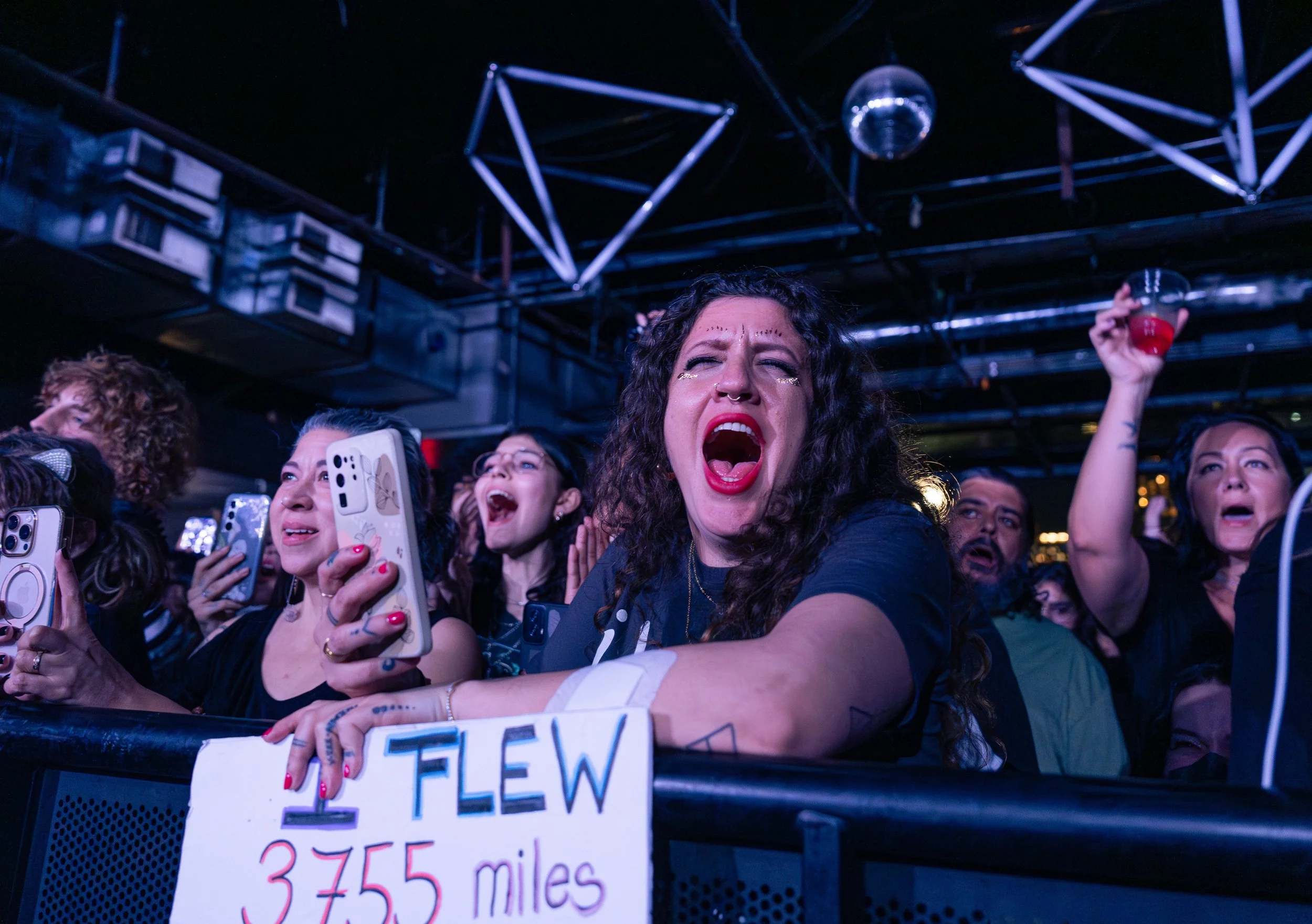  A fan holds a sign reading “I flew 3755 miles from Hawaii" while singing along to “Out in the Garden.” 