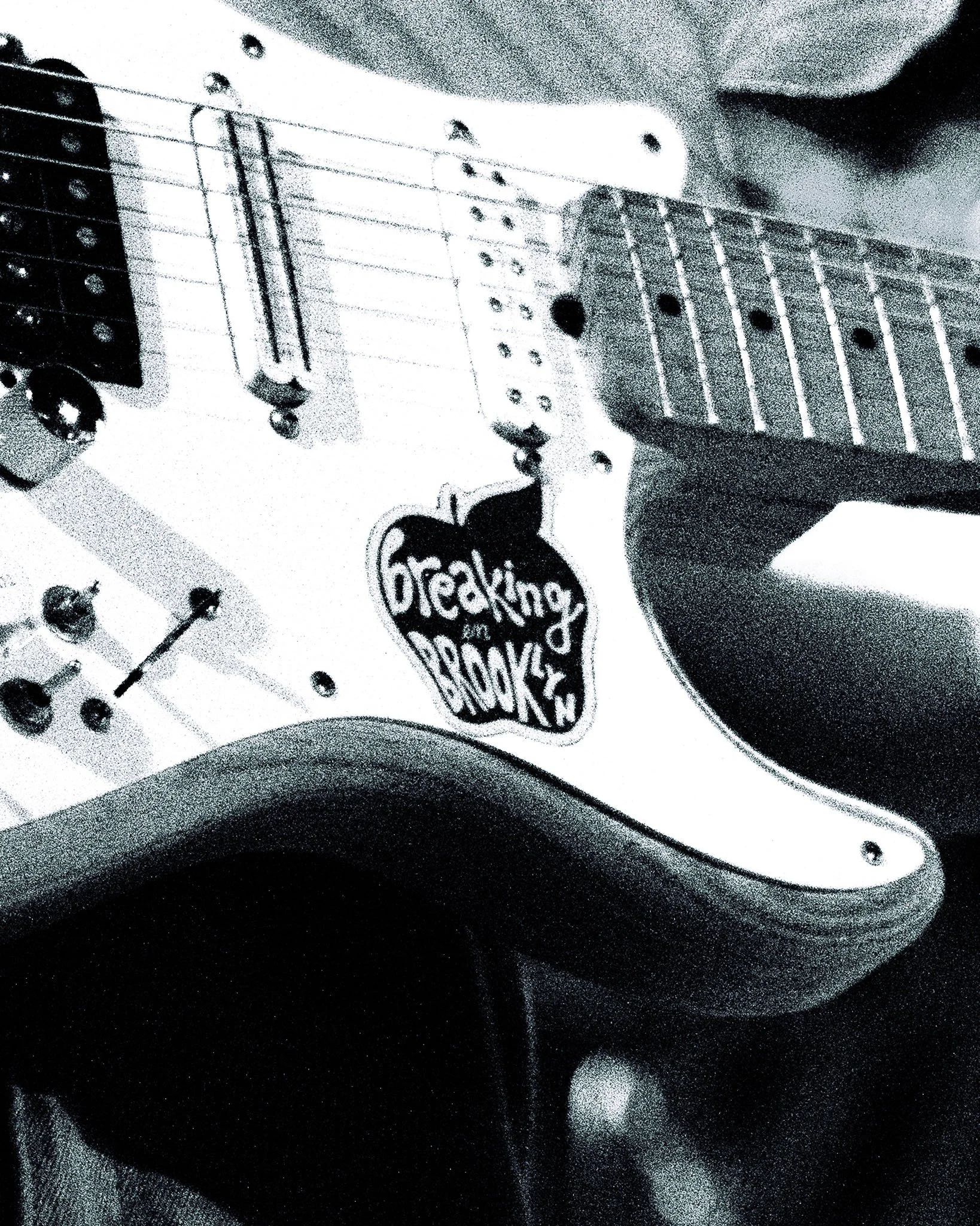  Billy Apostolou’s sticker for “Breaking in Brooklyn,” one of Dogpark’s most beloved songs, contrasts against his white guitar board. 