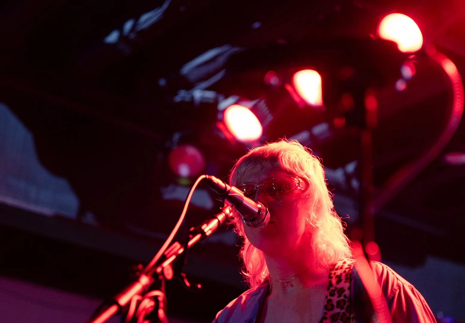  Cooper sings “Changes” to the crowd in red mood lighting. 