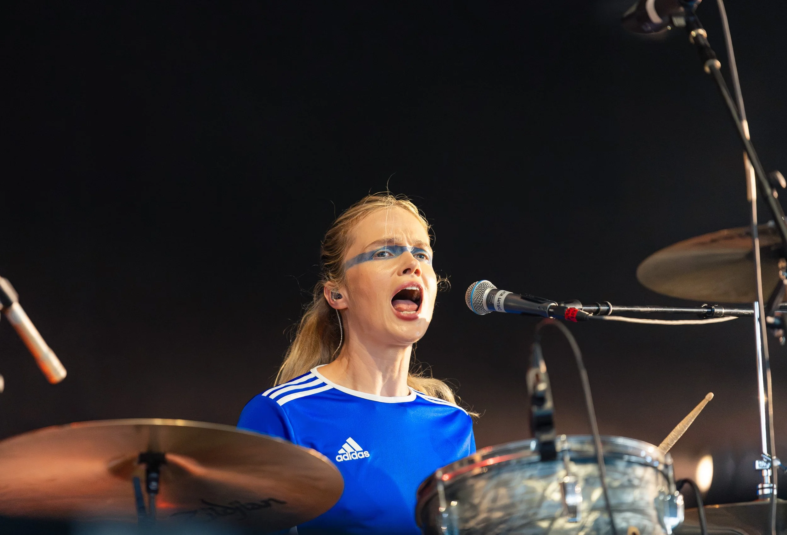  Drummer Florrie dramatically bangs on the drums and sings backup vocals during “I want love, but not that much.” 