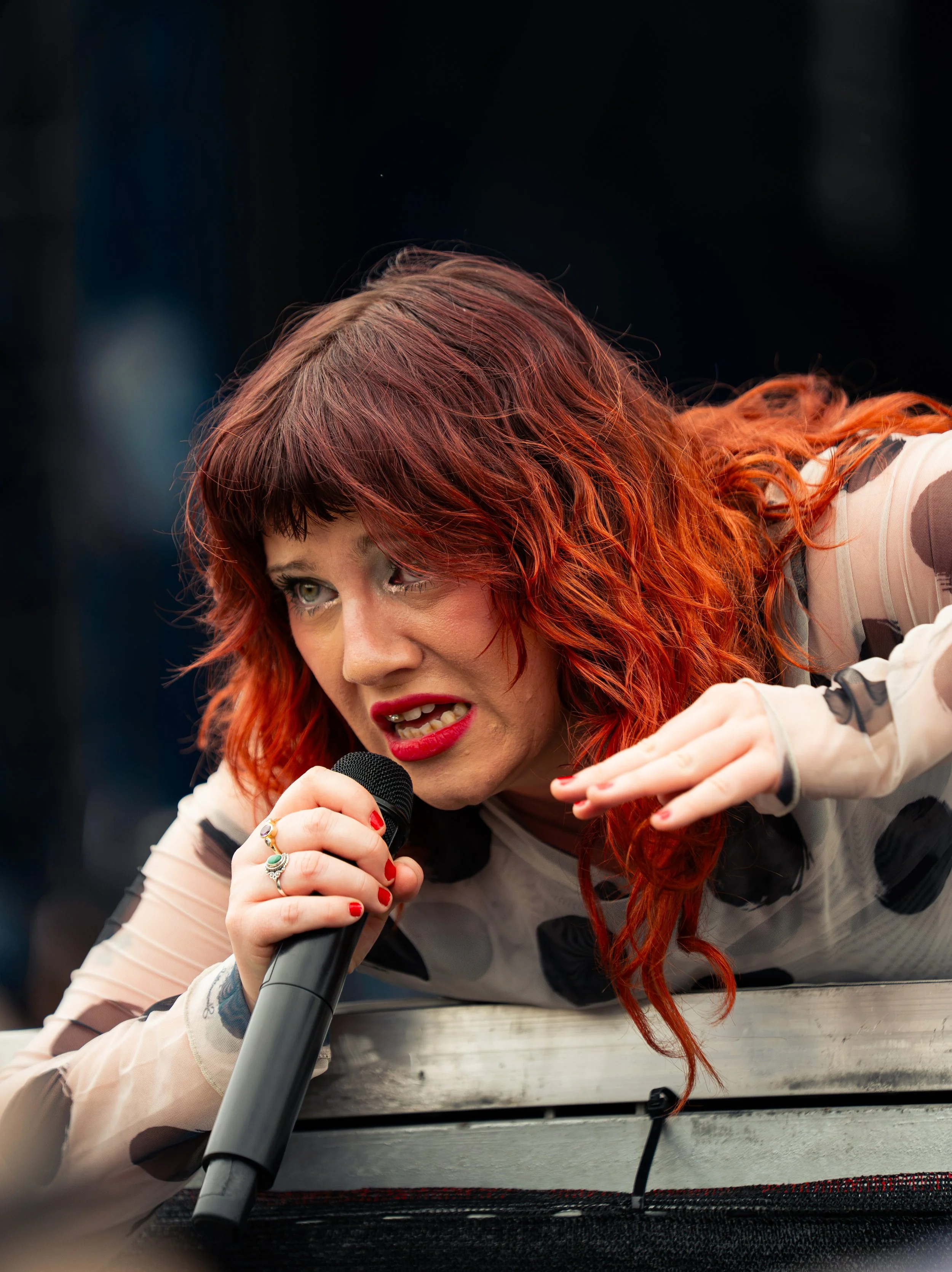  CMAT sings to fans as she leans over the edge of the stage while performing “I Don't Really Care for You.” 
