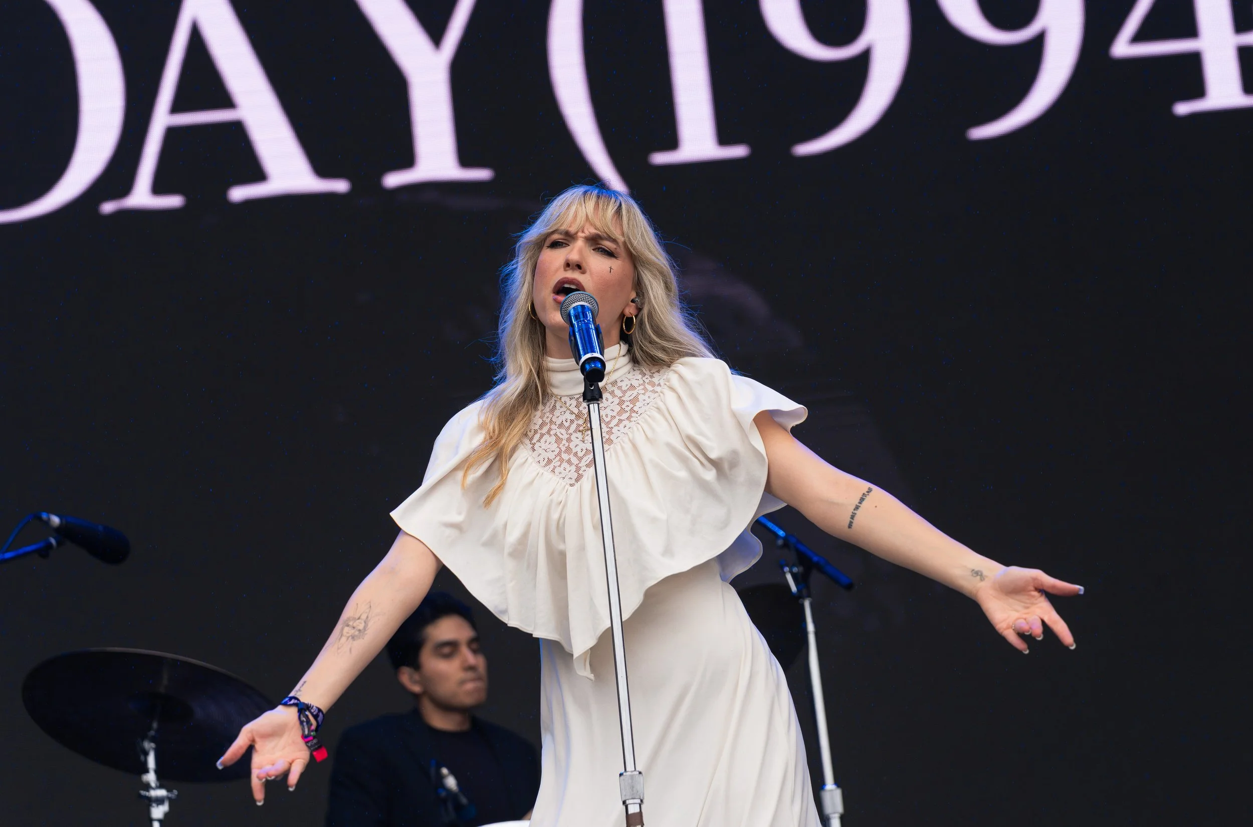  As rain hits the stage, Sunday (1994) lead singer Paige Turner sings the longing lyrics of “Rain”: “If I don't have you, then I've got nothing to lose, it's true / Did it even happen if you didn't see it too? / Now, the rain starts to fall.” 