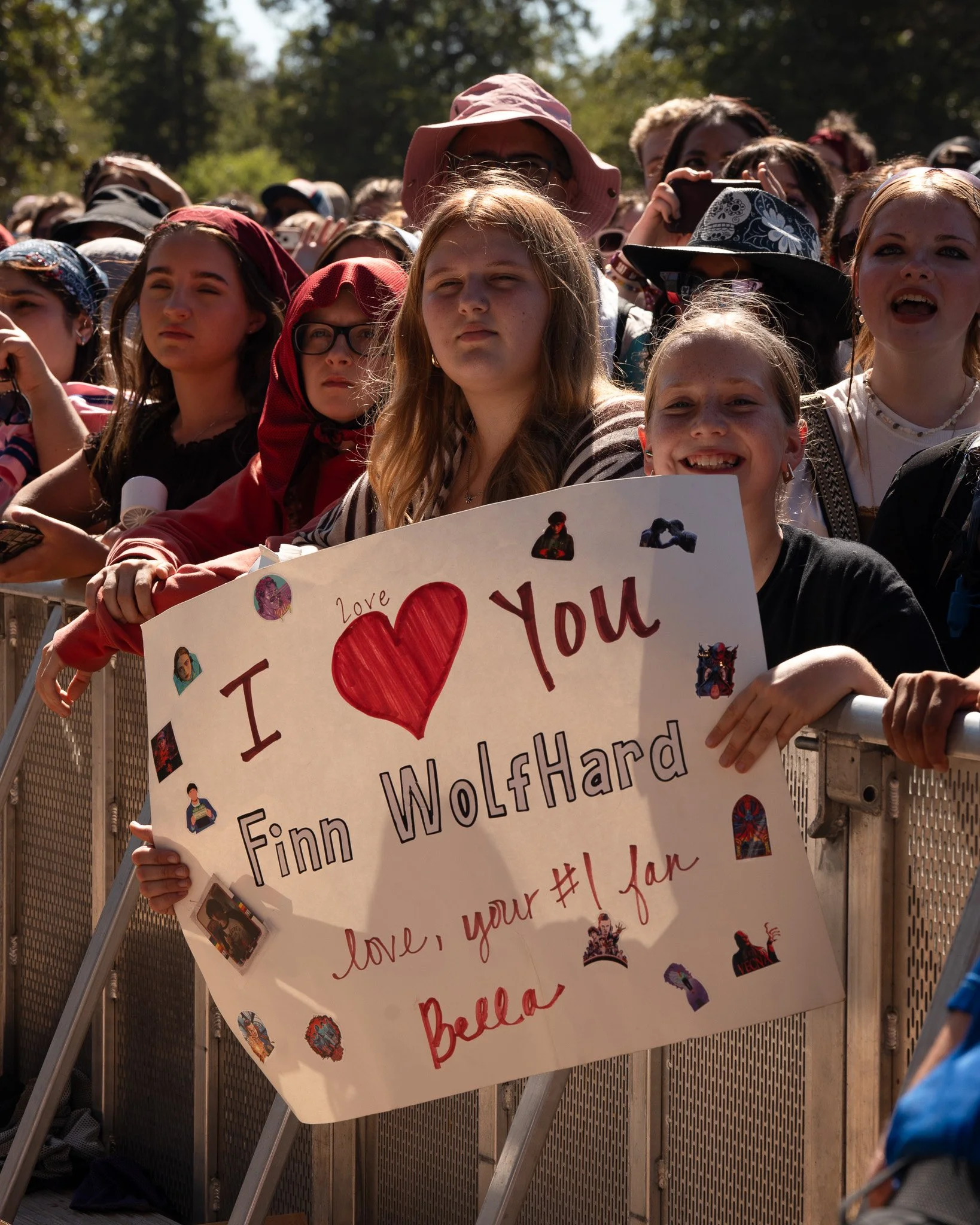  A fan on the barricade holds her poster out for Wolfhard. 