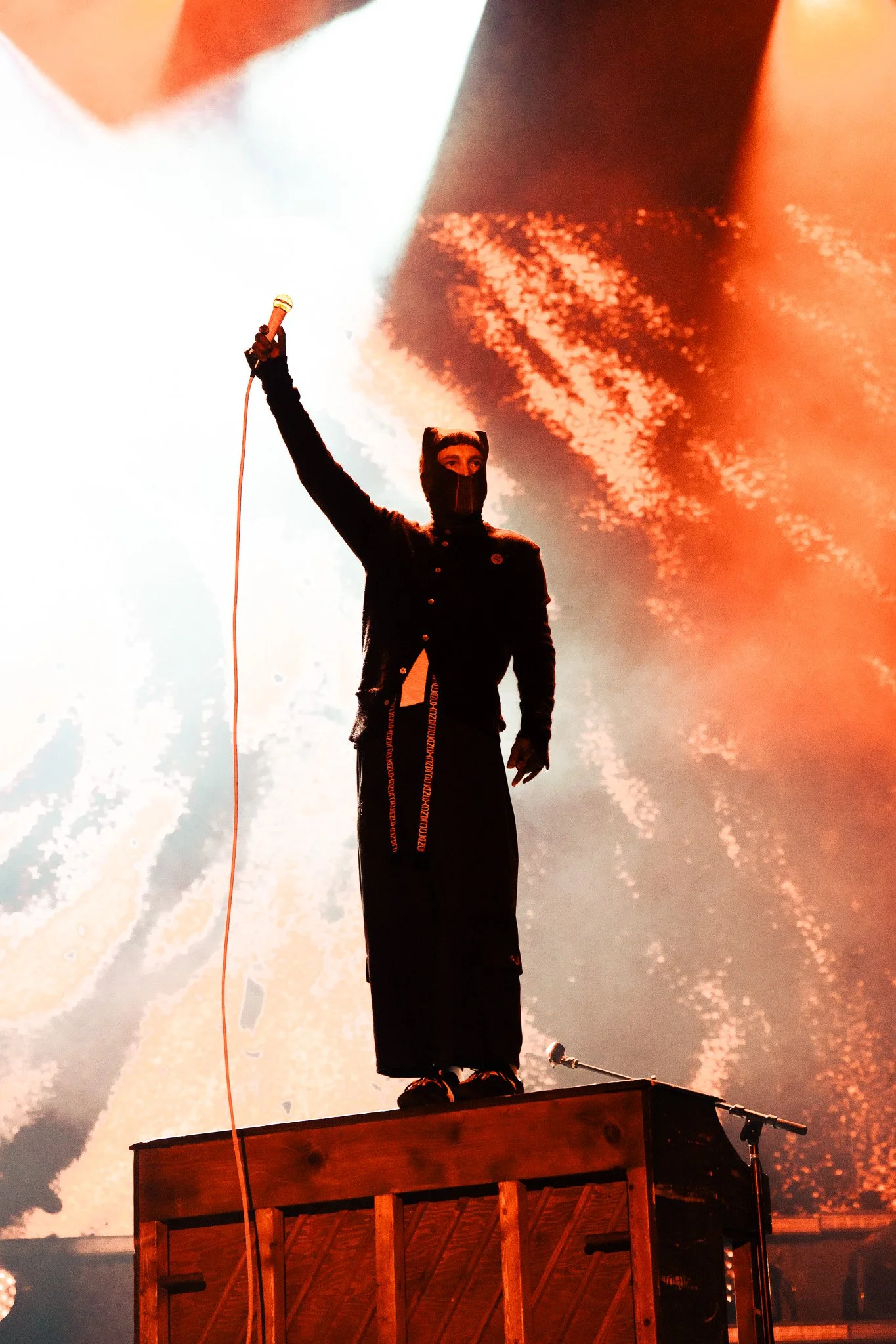  Joseph holds his microphone in the air before continuing “The Contract.” 
