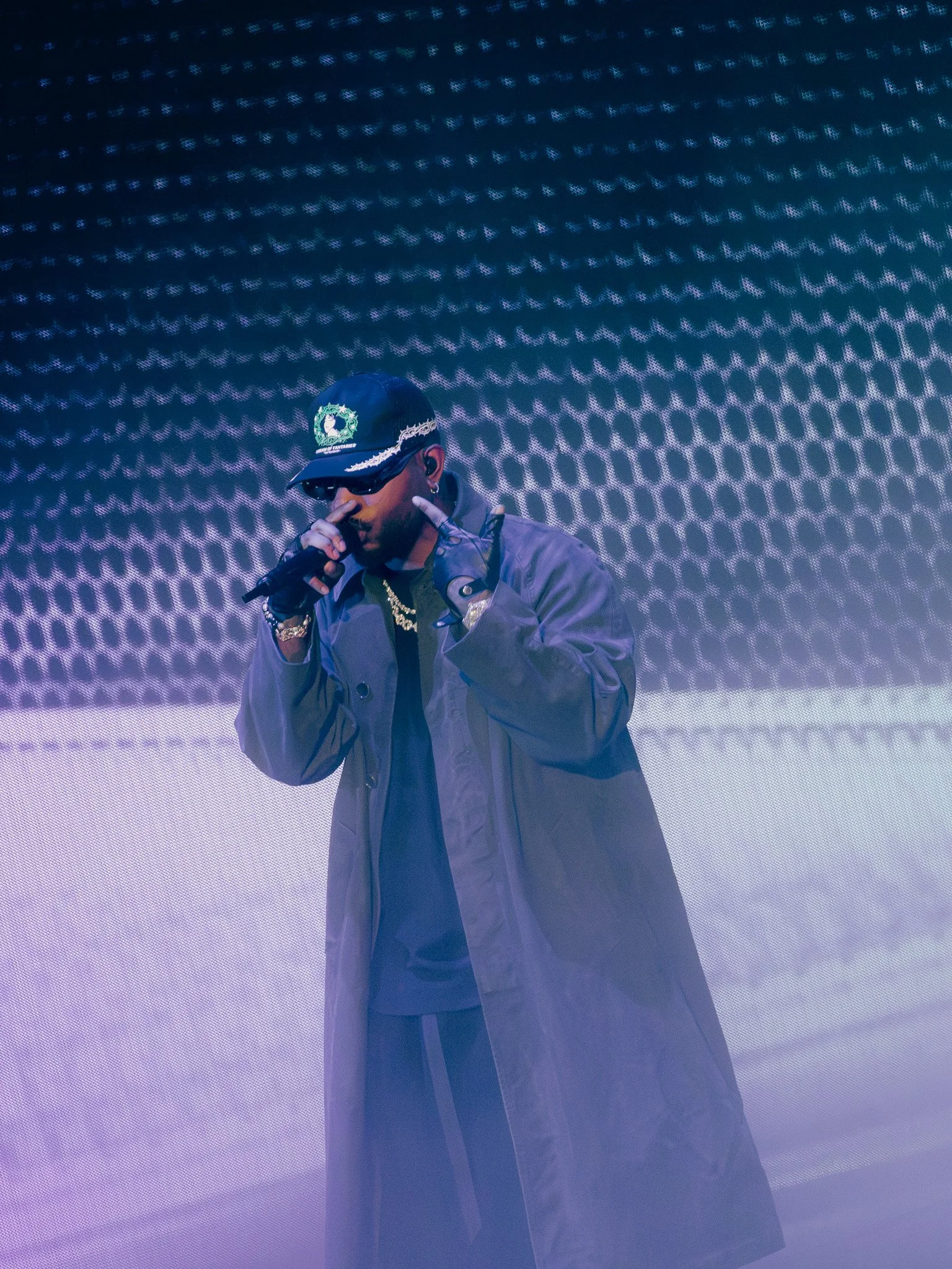  Tiller sings into the microphone in front of blue and purple-lit screens during the performance of “Don’t.” 