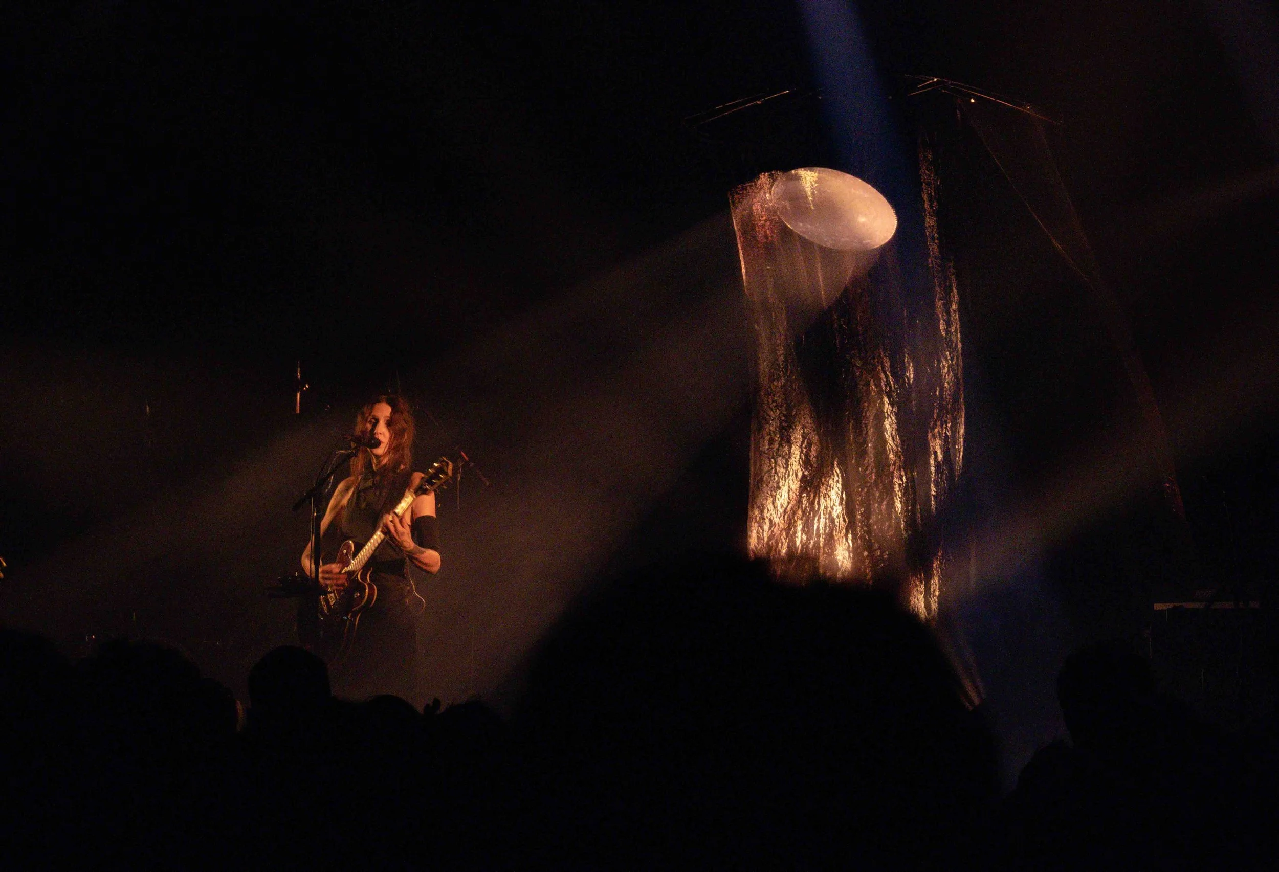 Wolfe stands in yellow mood lighting while performing “Turn the Key” from her latest album  The Dark . 