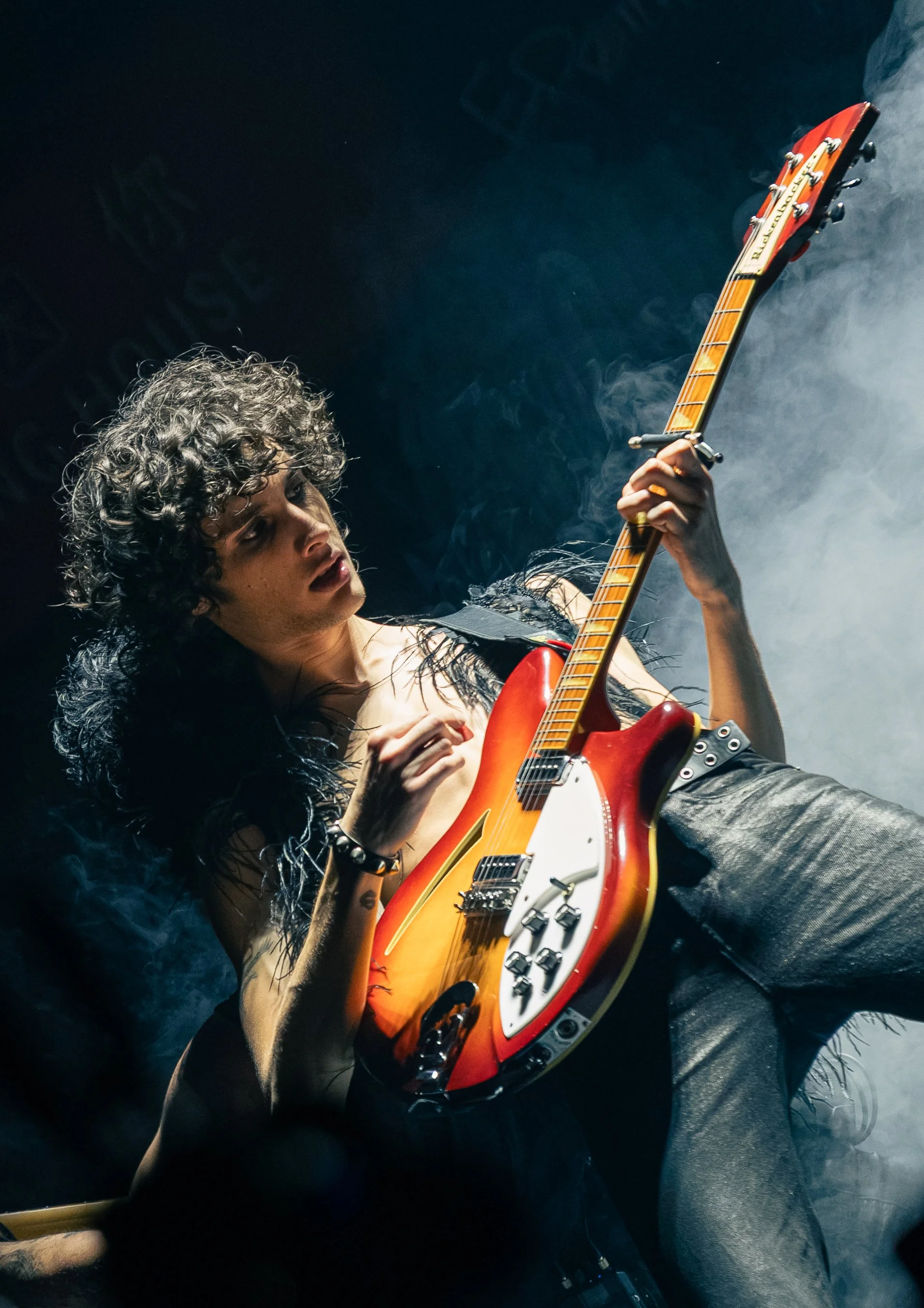 Boose leans against another guitarist while passionately strumming the guitar and humming the starting notes of “Homewrecker.” 