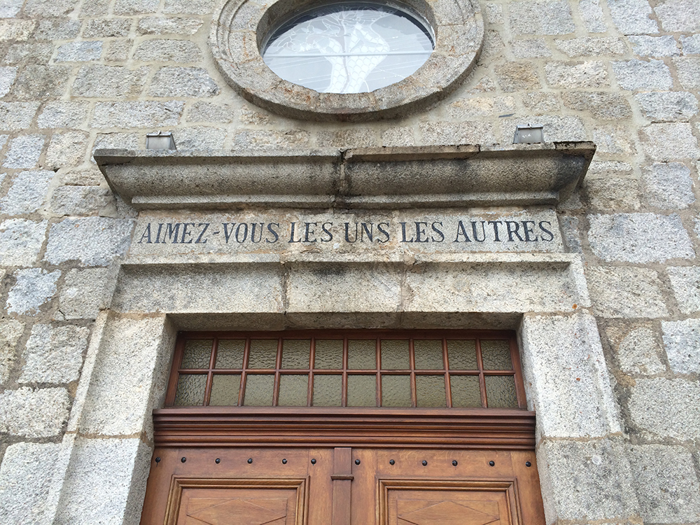 The sign above the door reads “Love One Another”