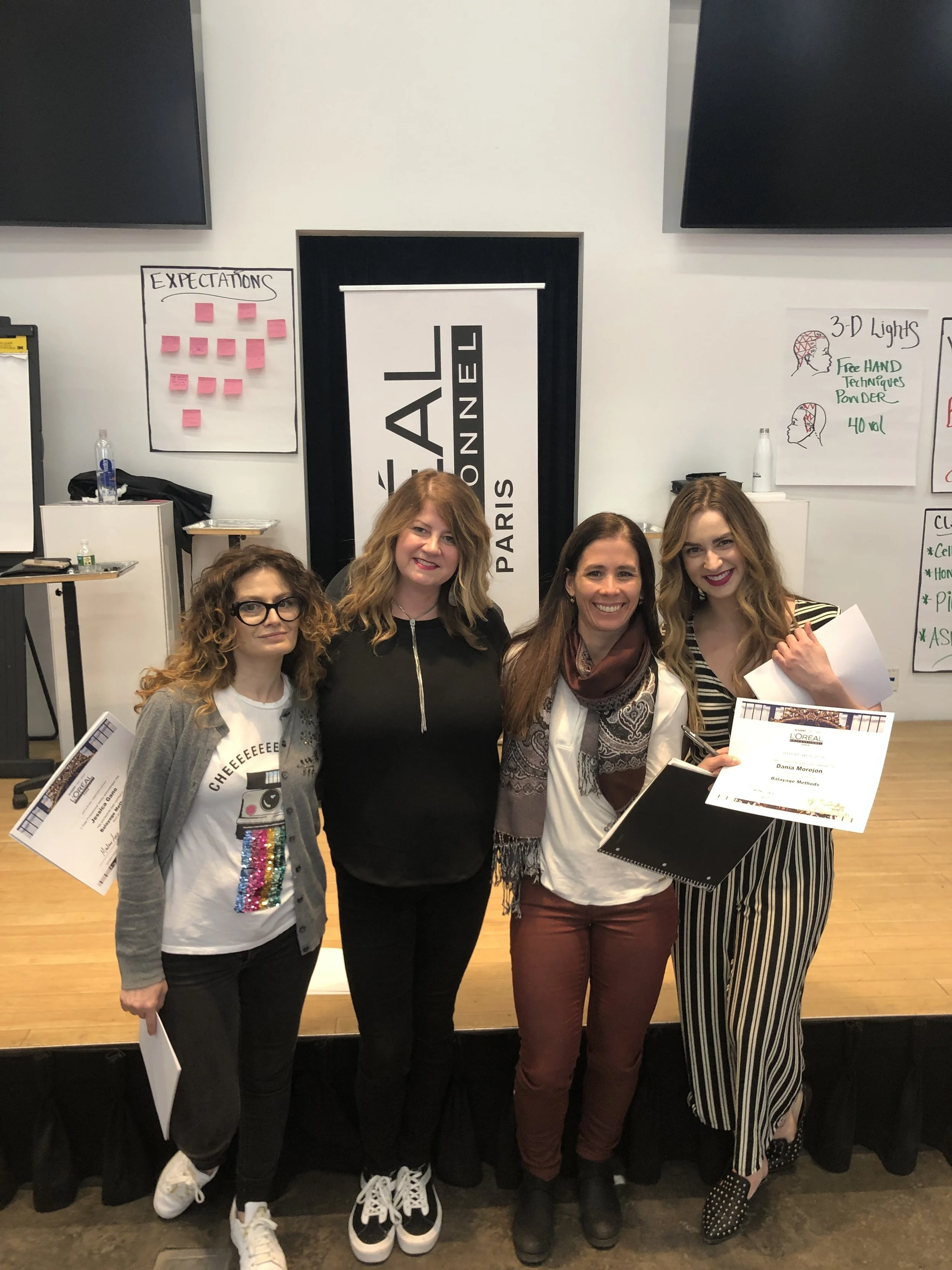 Hairstylists in a group photo with certifications