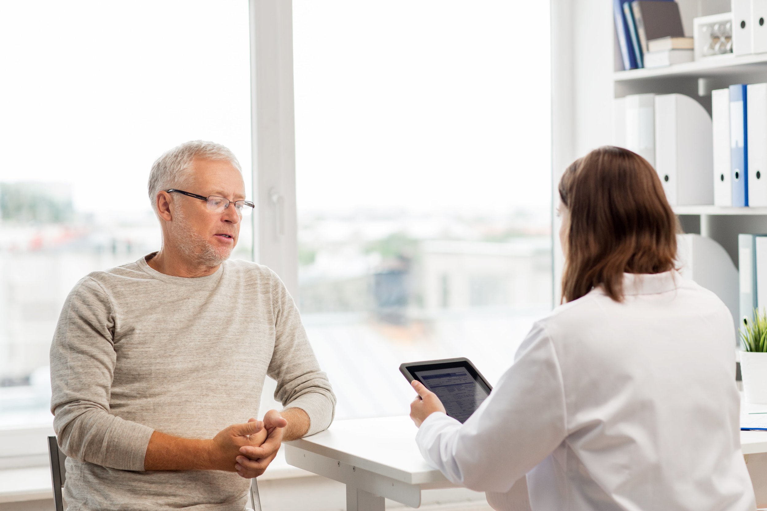 senior-man-and-doctor-with-tablet-pc-at-hospital-PJPXHGR.jpg