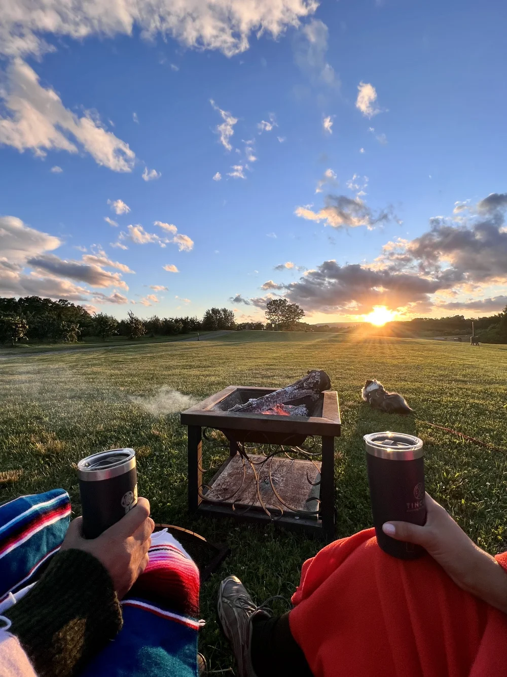 Cozy couple drinking in front of a fire pit at sunset in Gardiner New York