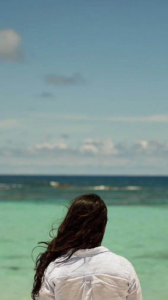 Woman looking onto a pristine blue beach in British Virigin Islands