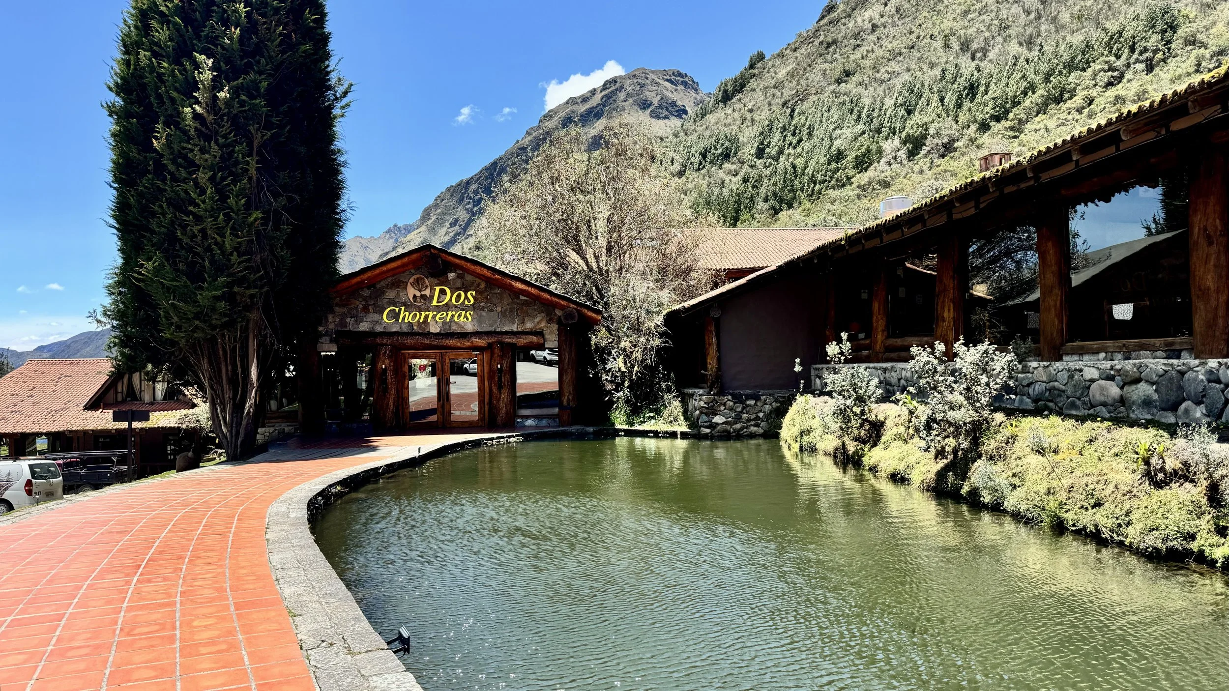 The Hostería Dos Chorreras lodge and pond, set against the Andes mountains near Cajas National Park