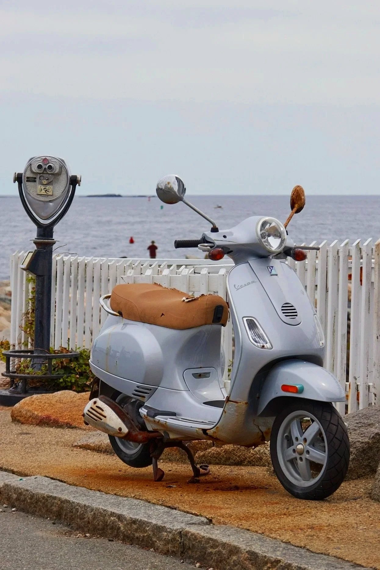 Coin-operated viewfinder and vintage scooter overlooking the Atlantic Ocean in Rockport, Massachusetts