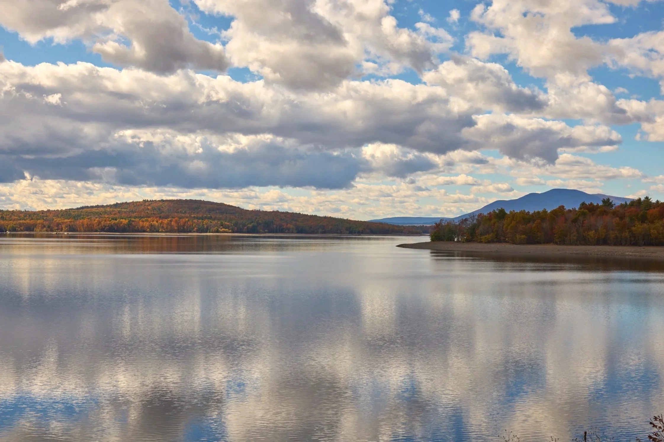 Ashokan Reservoir in the Catskills with dramatic clouds and fall foliage along the shoreline, upstate New York