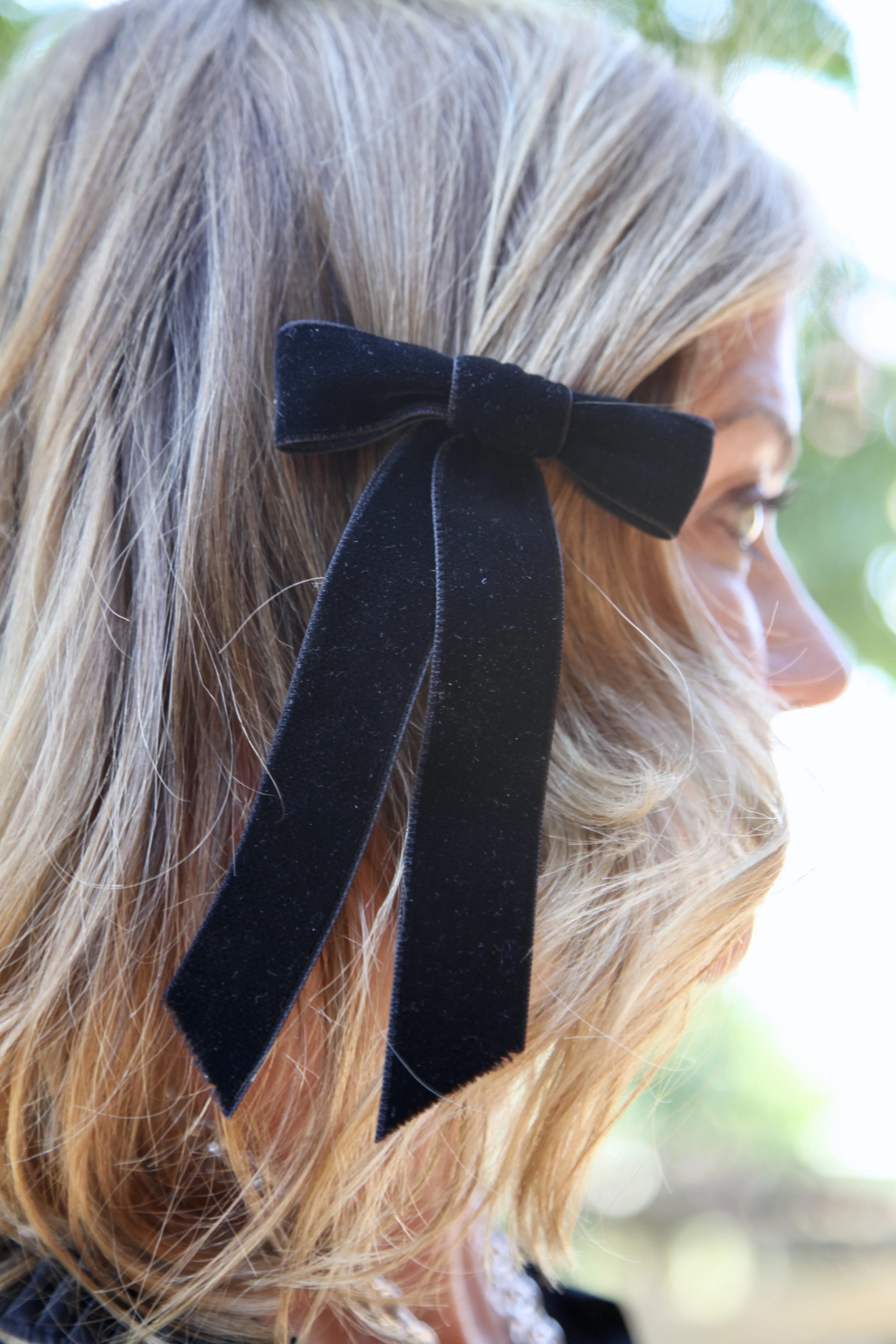 Pull back bangs with a small velvet bow or tie your hair away from your face with a simple twist.