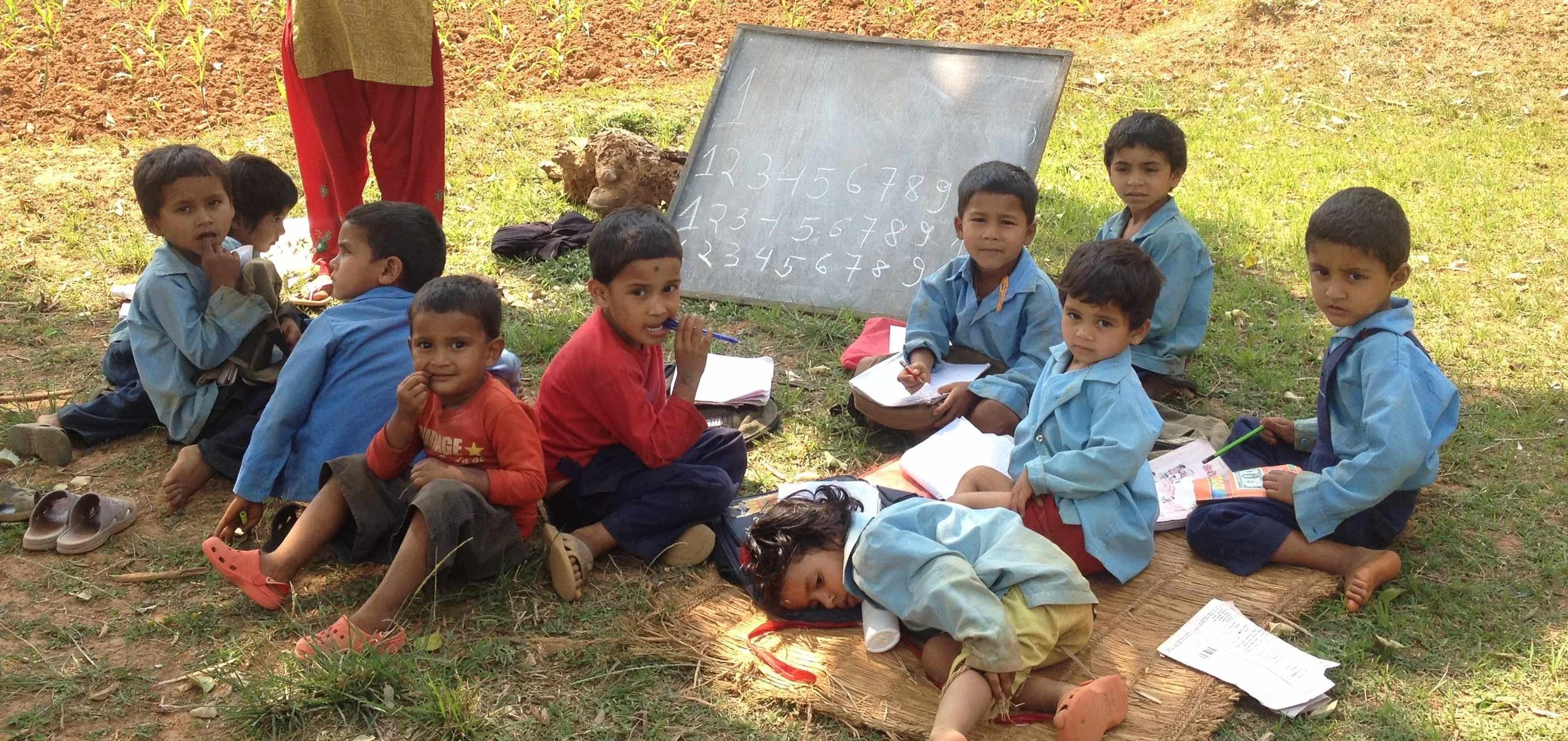 Nepali pre-school children in Gorkha district, learning outside because there is no Kindergarten or primary school to house them.